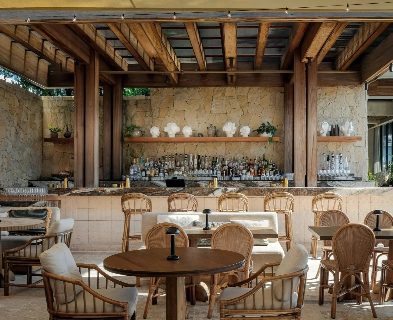 Outdoor beach club with a bar and tables, capturing CASA NEOS Beach Club