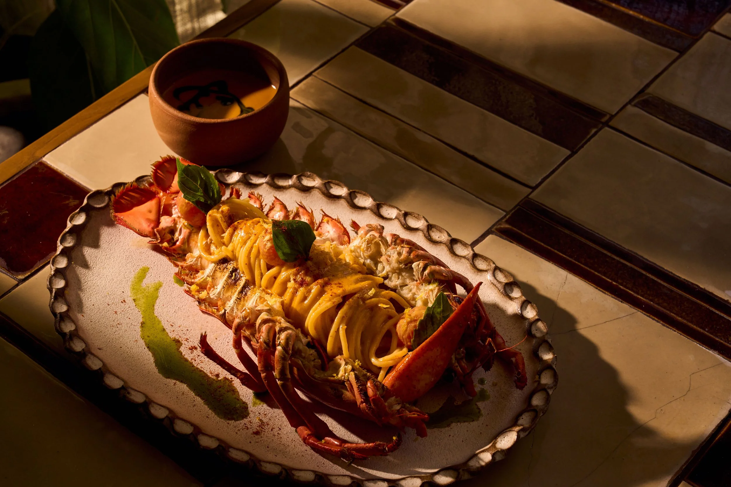 CASA NEOS iconic lobster pasta dish, on a table elegantly presented.