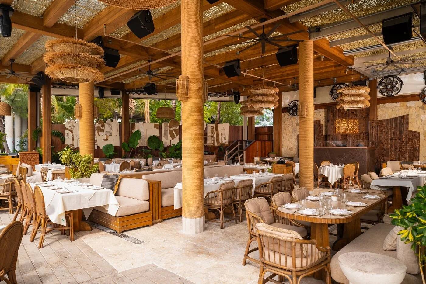 Tables and chairs in the beach club area of CASA NEOS.