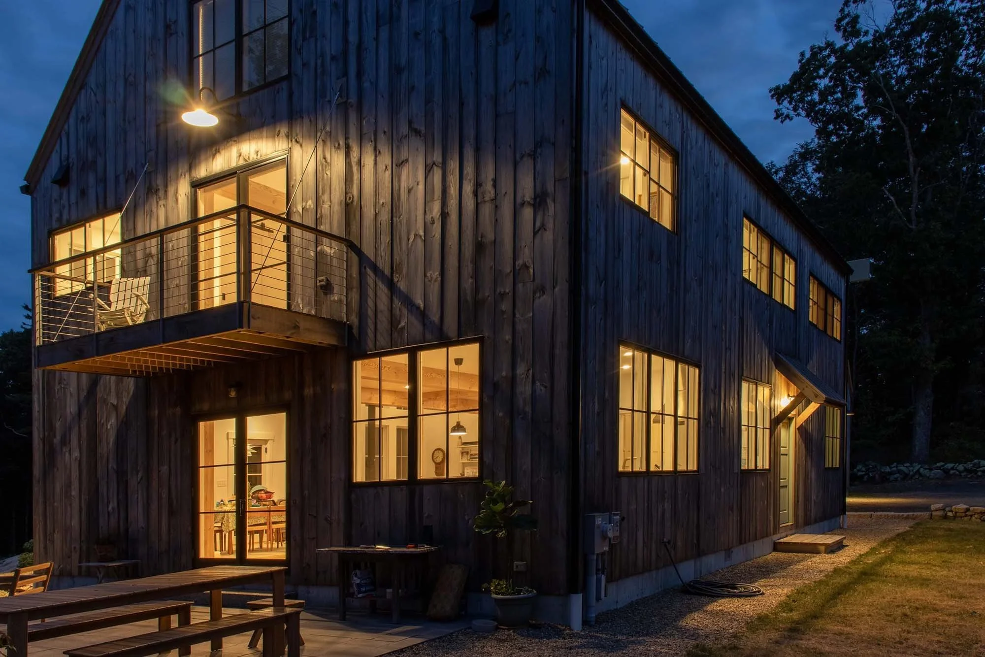 night view of exterior custom house with warm light and black windows and balcony
