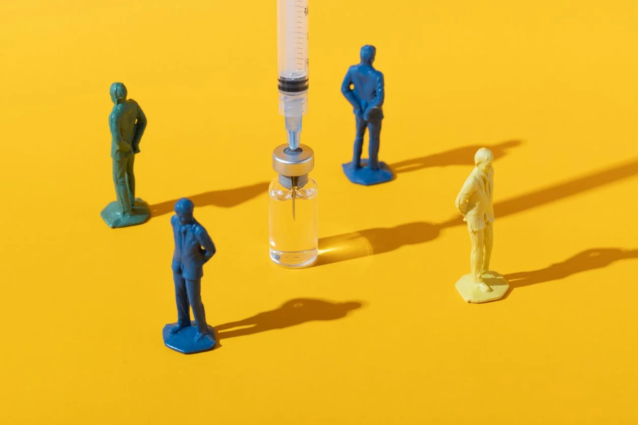 Vaccine needle and vial, with four figurines with their backs turned to it