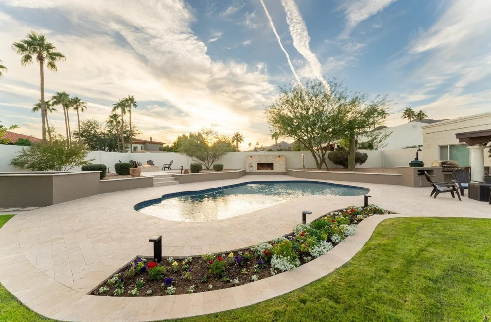 Sunset pool with a broad paver deck