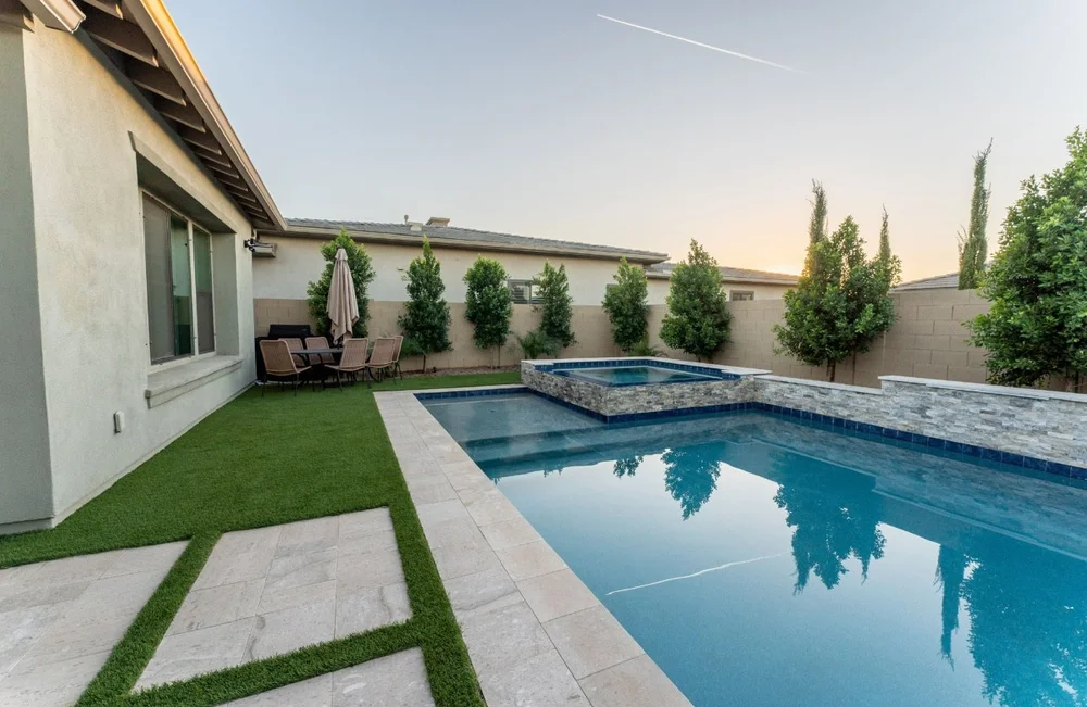 Stepping pavers in grass beside a pool and spa
