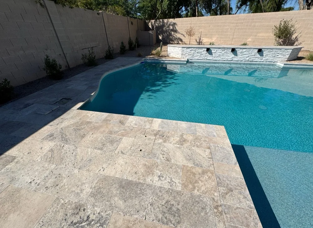 Stone deck surrounding a turquoise pool