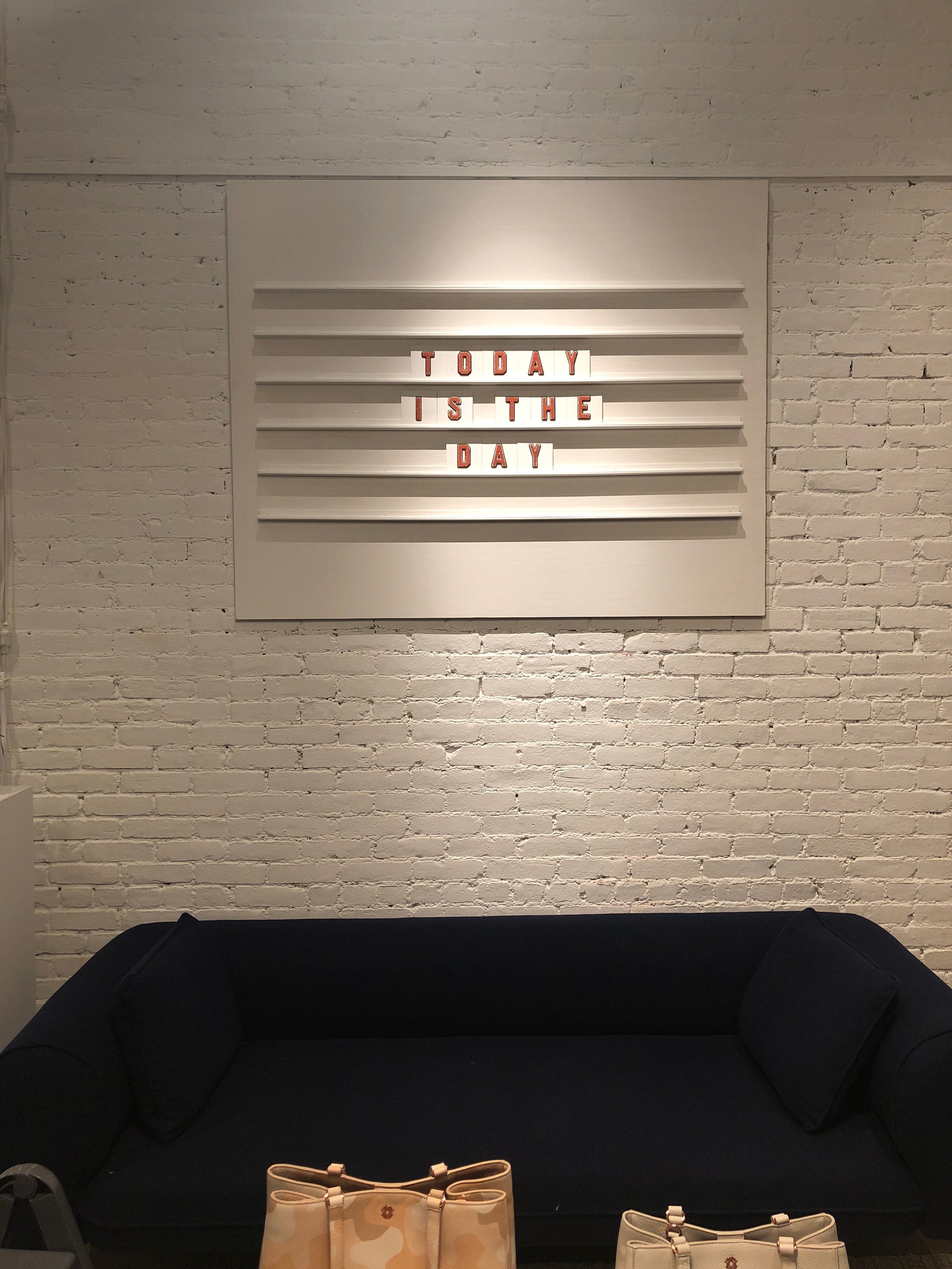 Custom fabricated sign mounted for a handbag brand's store.