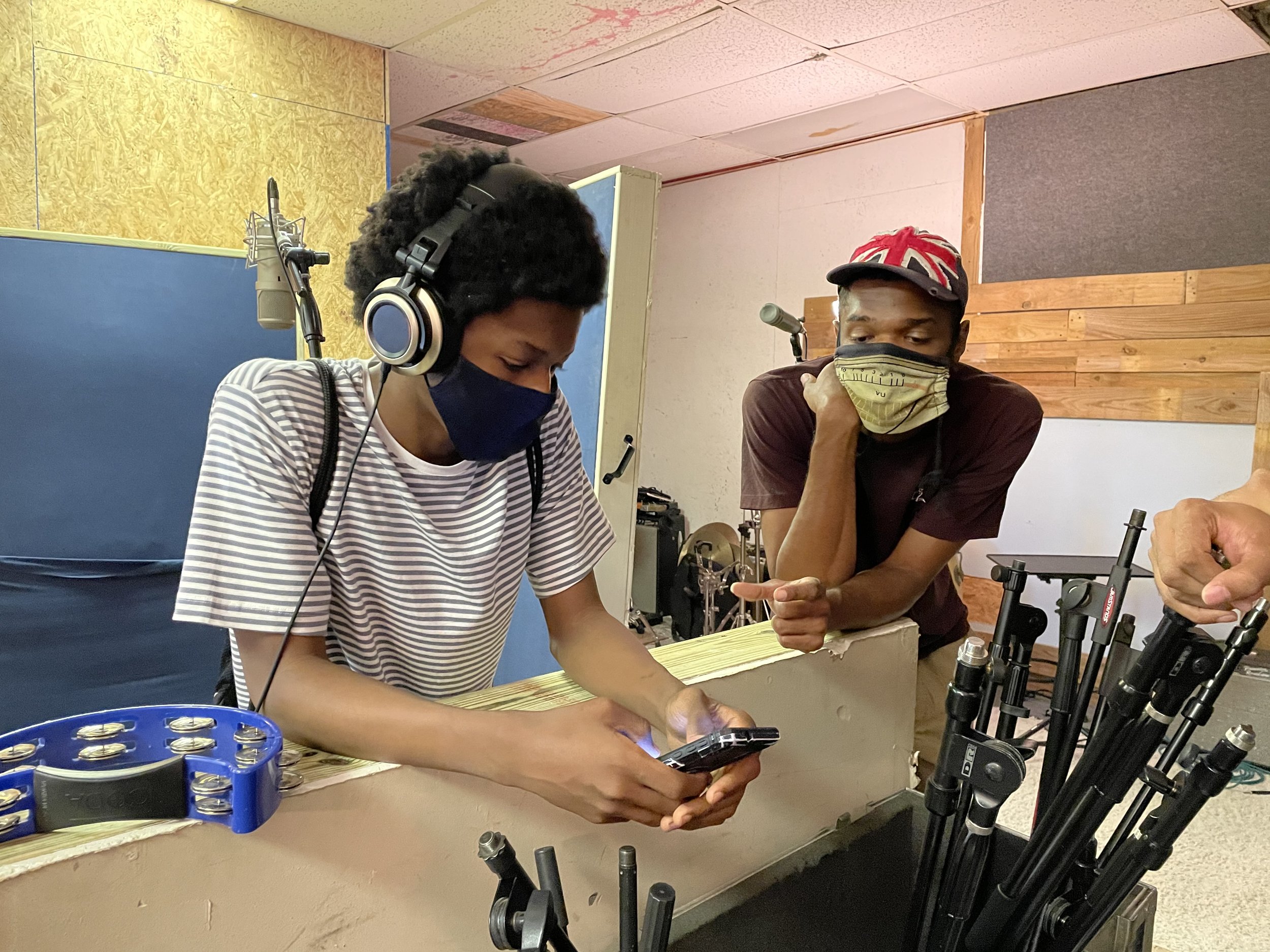Roots students learned from many mentors. Here, a young musician is getting tips from a recording studio owner on how to expand his sound.
