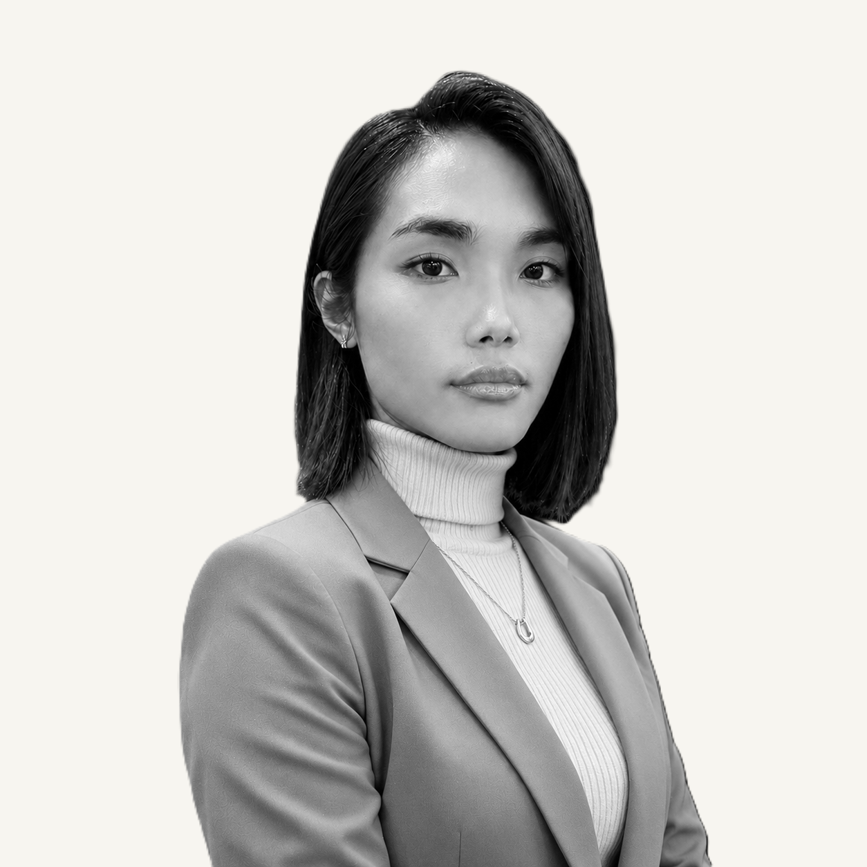 A black and white portrait of Vee Vargas wearing a satin shirt and a necklace, looking directly at the camera with a neutral expression.