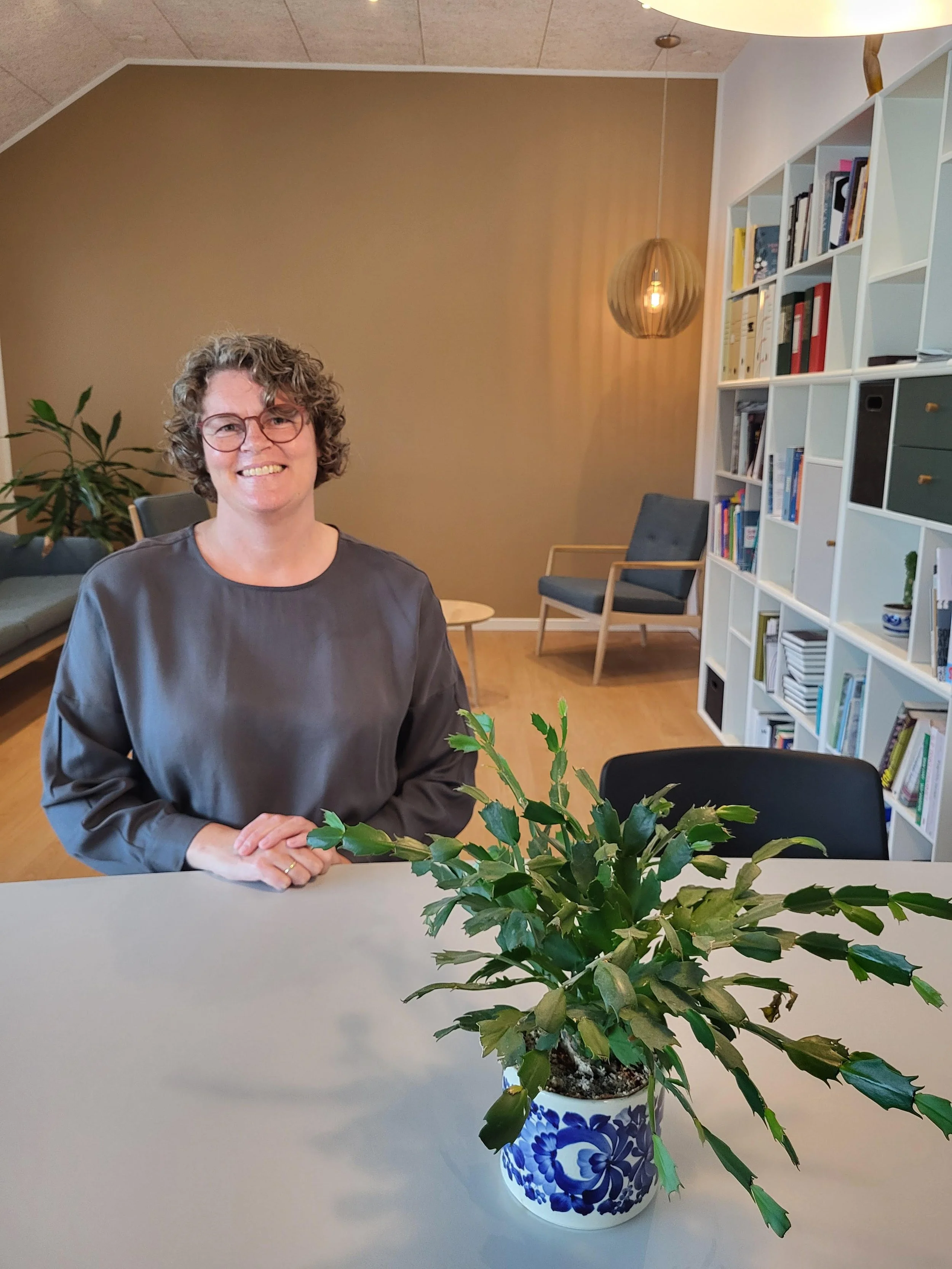 Ruth sidder ved gruppebord i terapilokale