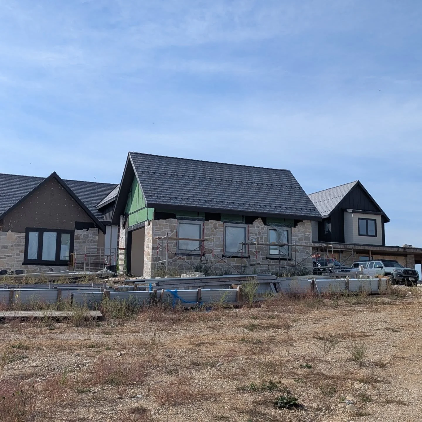 The exterior of project 149 is almost complete! The TruExterior siding is on and stone is going up. Davinci slate roof is complete and the standing seam roof still needs to go on 

@davinciroof 
@westlakeroyalbuildingproducts 
#customhome #homebuild 