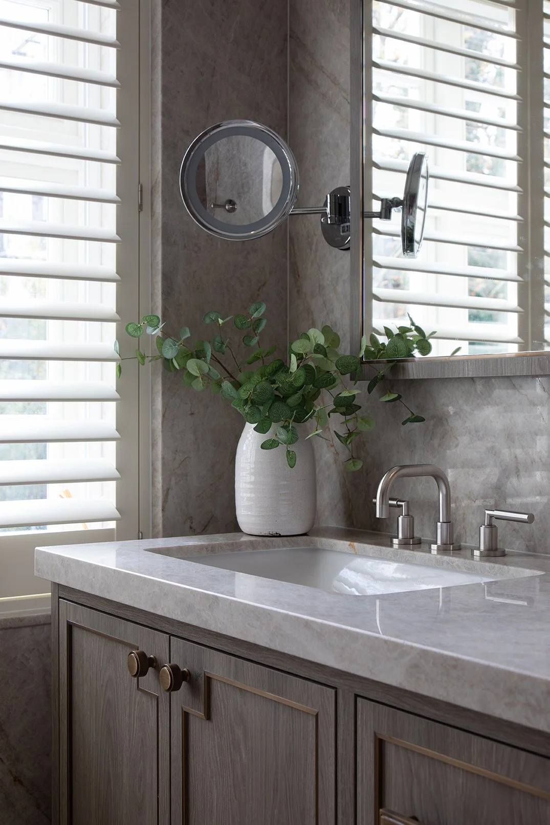 A bathroom with marble walls and counter tops