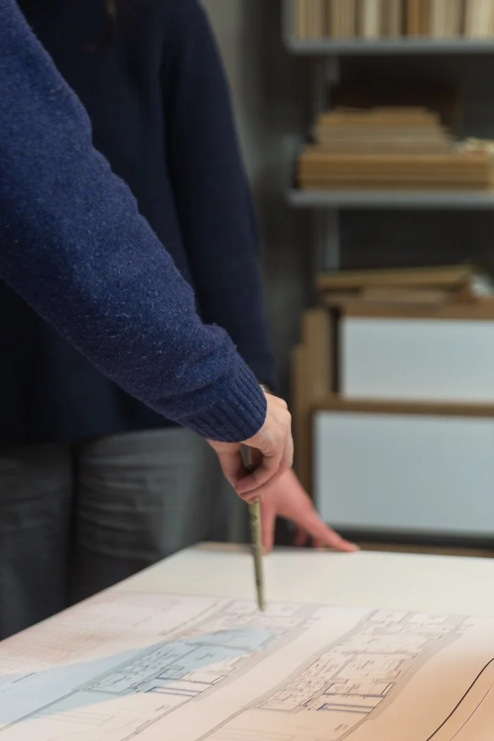 Hand pointing as design plans at JLE Studio in London