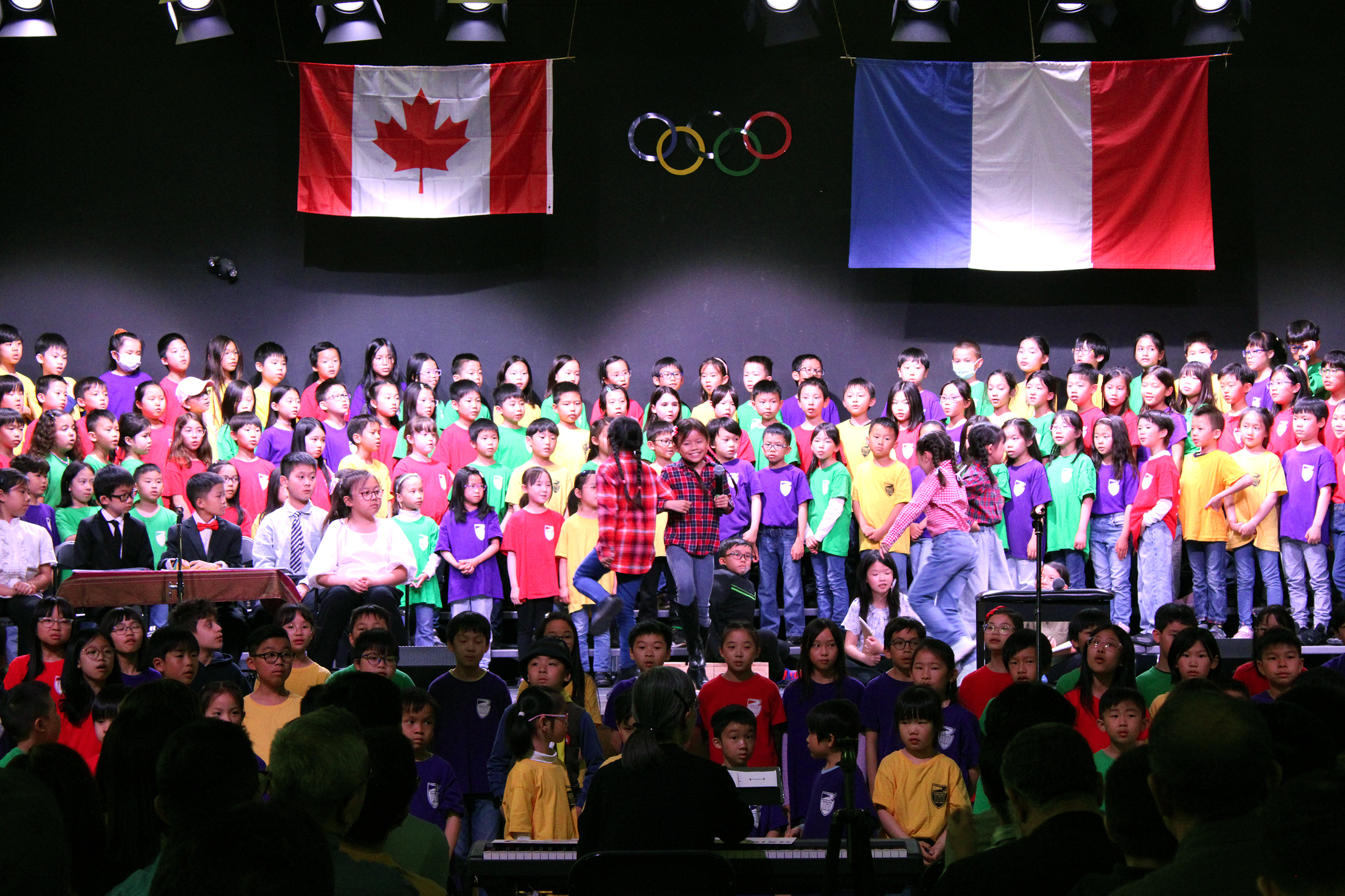 Students dancing on the stage, twirling with a partner with linked arms
