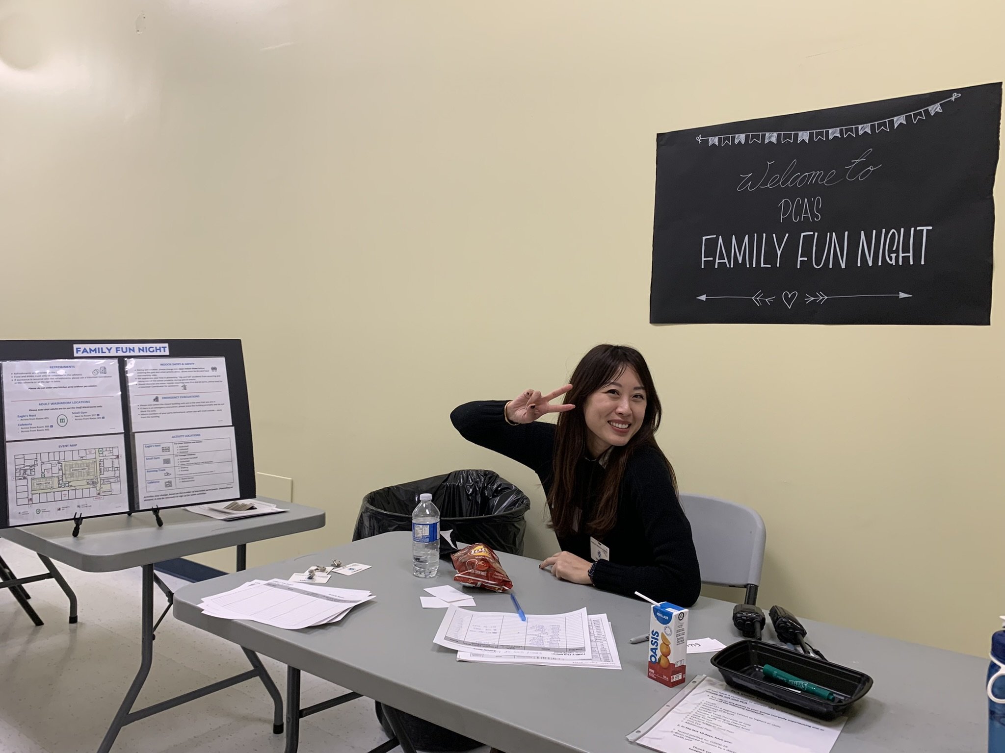Parent volunteer sitting at Family Fun Night table