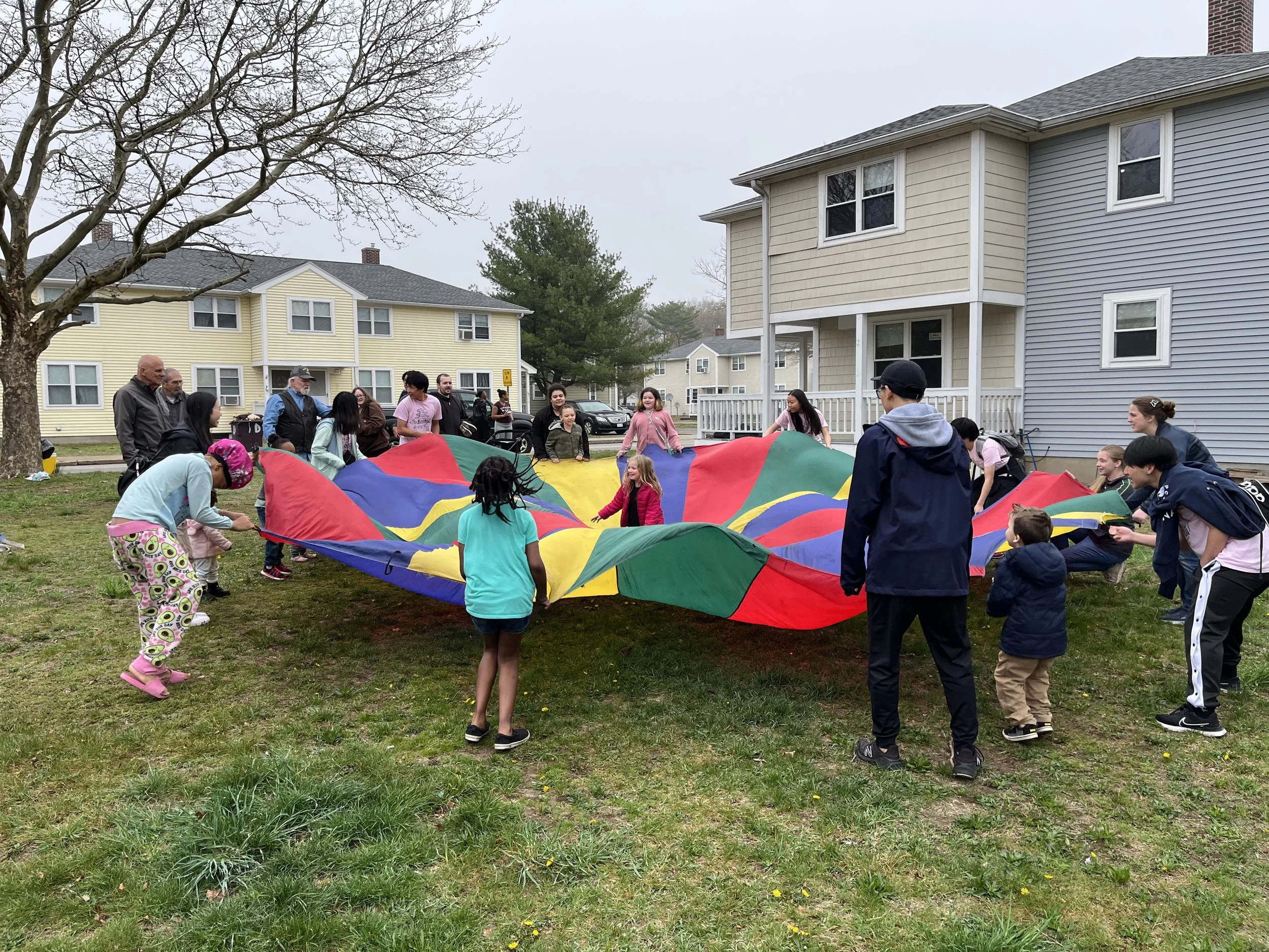 Day 2 - Mission team members and neighbourhood children are playing together with a parachute
