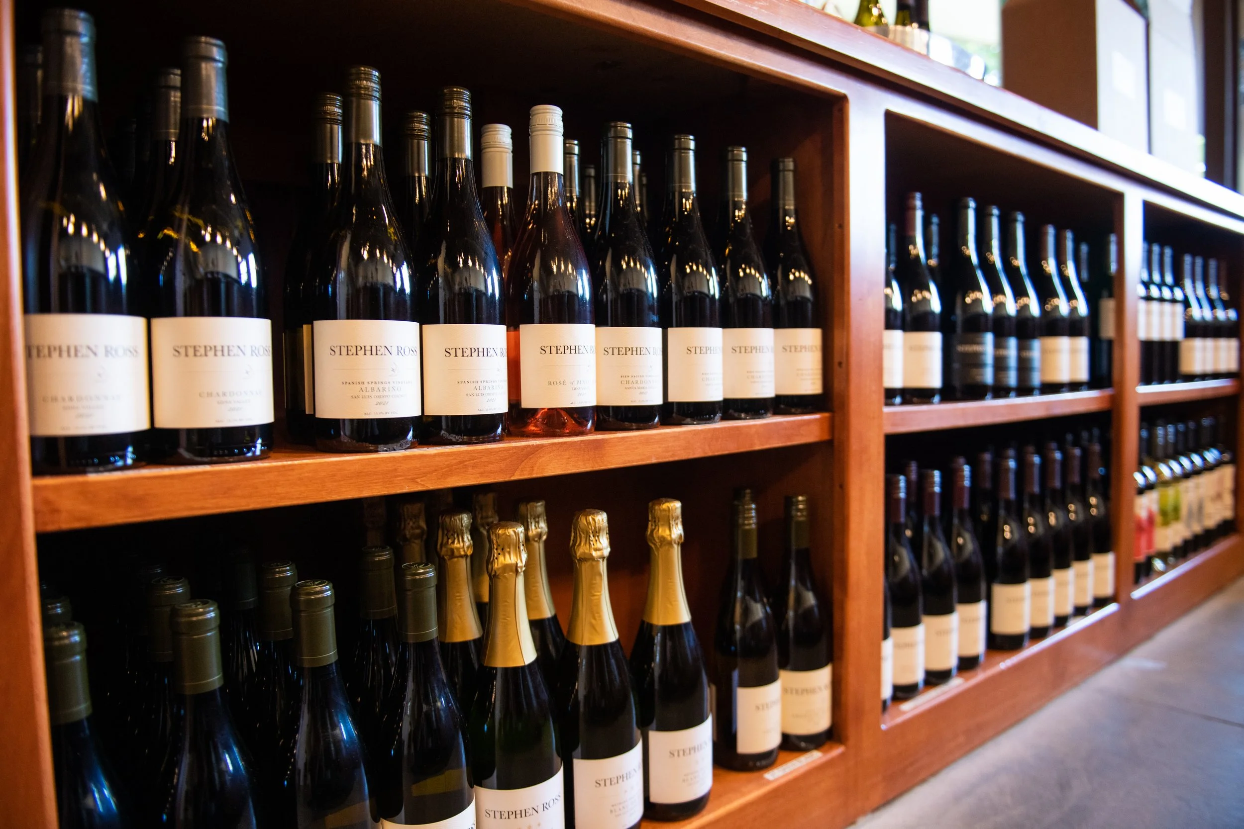 Bottles sit upright in rows on shelves