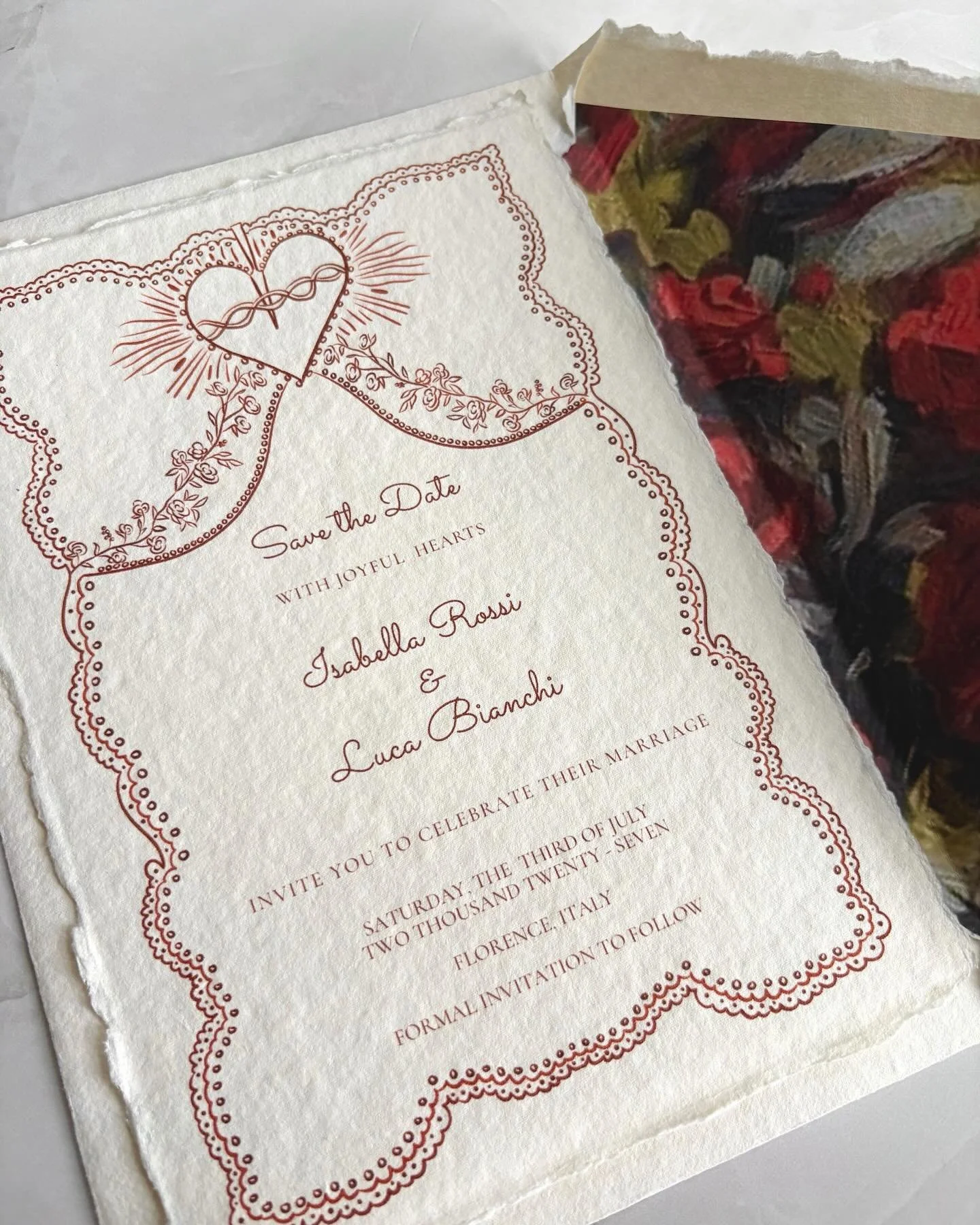 An Italian love story, told through paper.

Deckled edges, lace inspired trim, and hand drawn details that whisper, each element chosen with meaning.

The sacred heart, a symbol of devotion and enduring love.
Roses, for romance, beauty, and the unfol