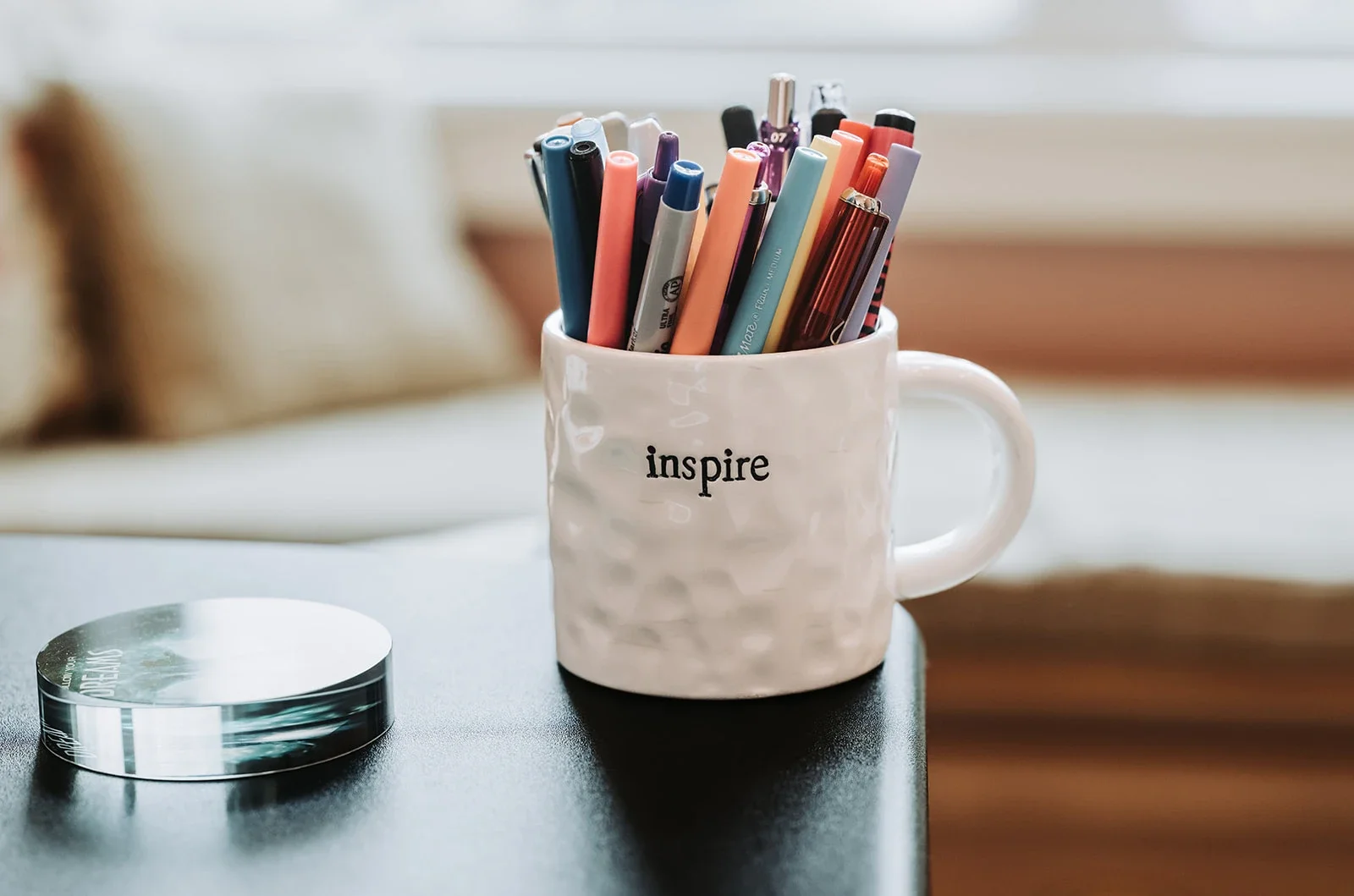 Coffee mug holding pens that says "inspire" on it