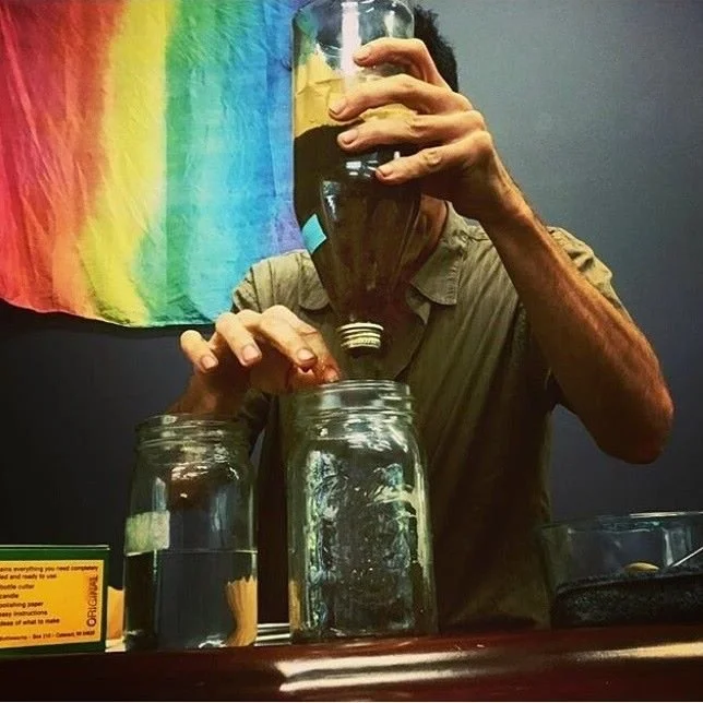 Dave demonstrating percolation at an herb school in front of a rainbow flag