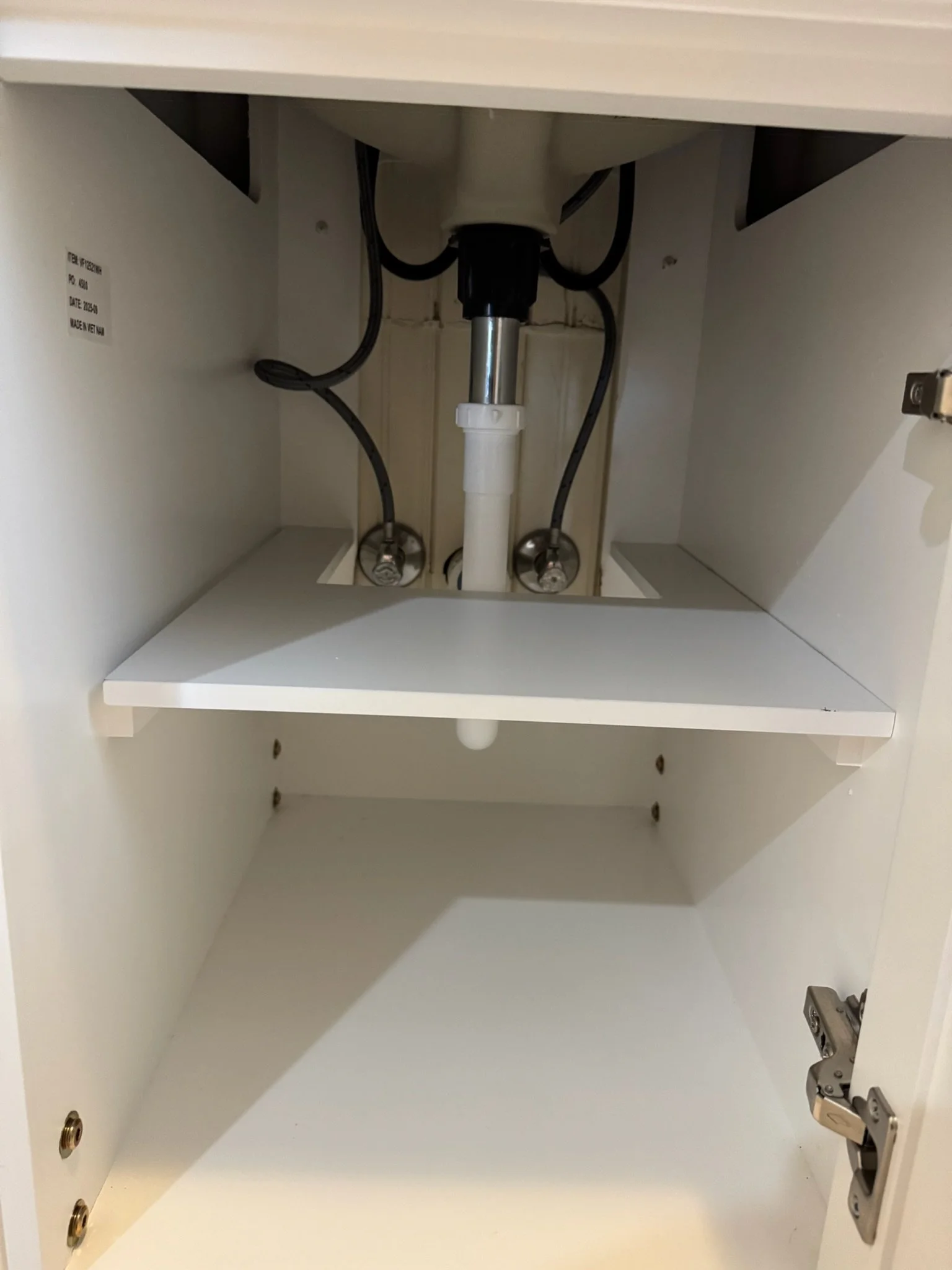 Drain and water-supply connections inside the bathroom vanity.