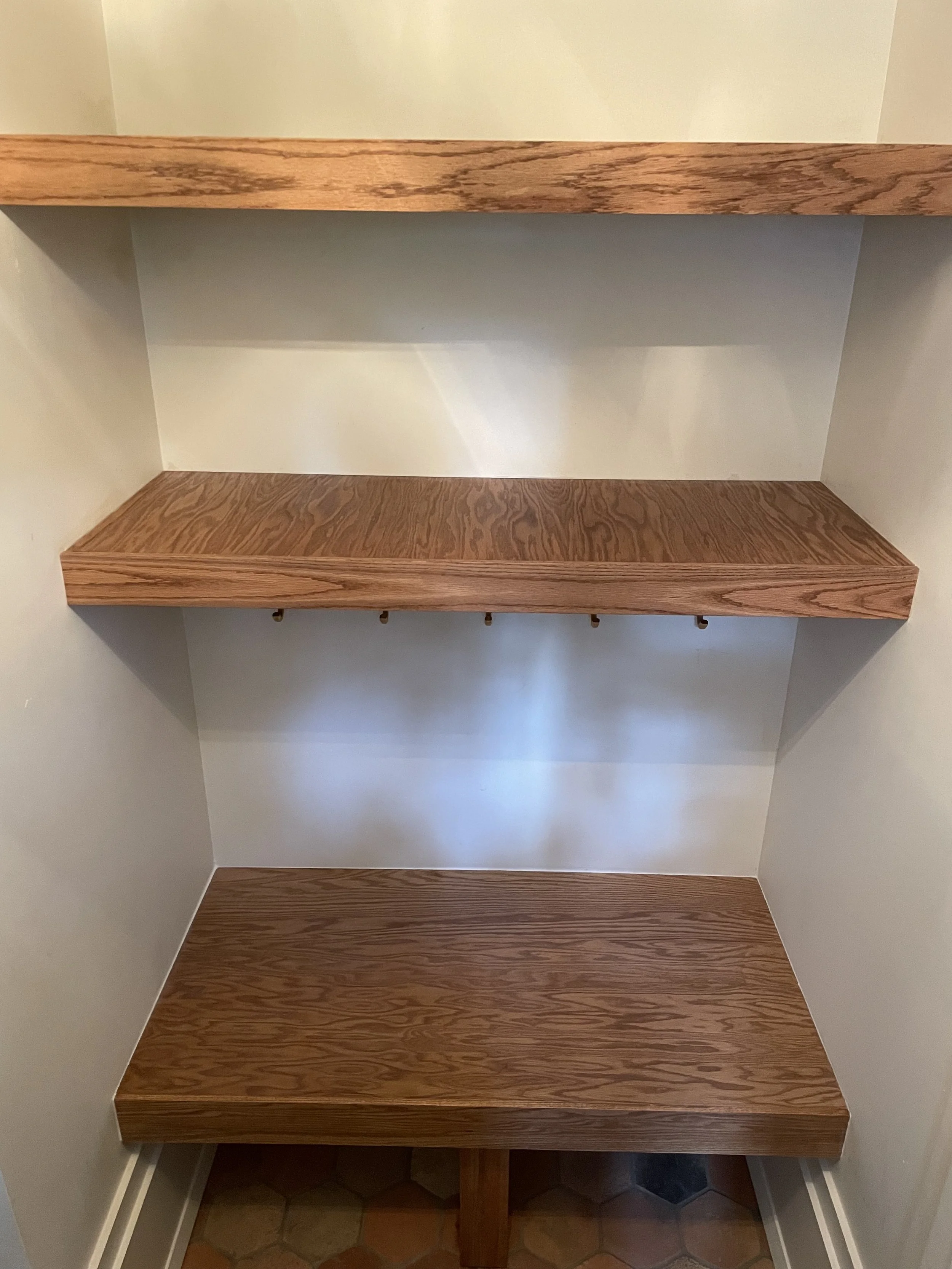 Overhead view of the oak entry shelves, bench and shoe storage space.