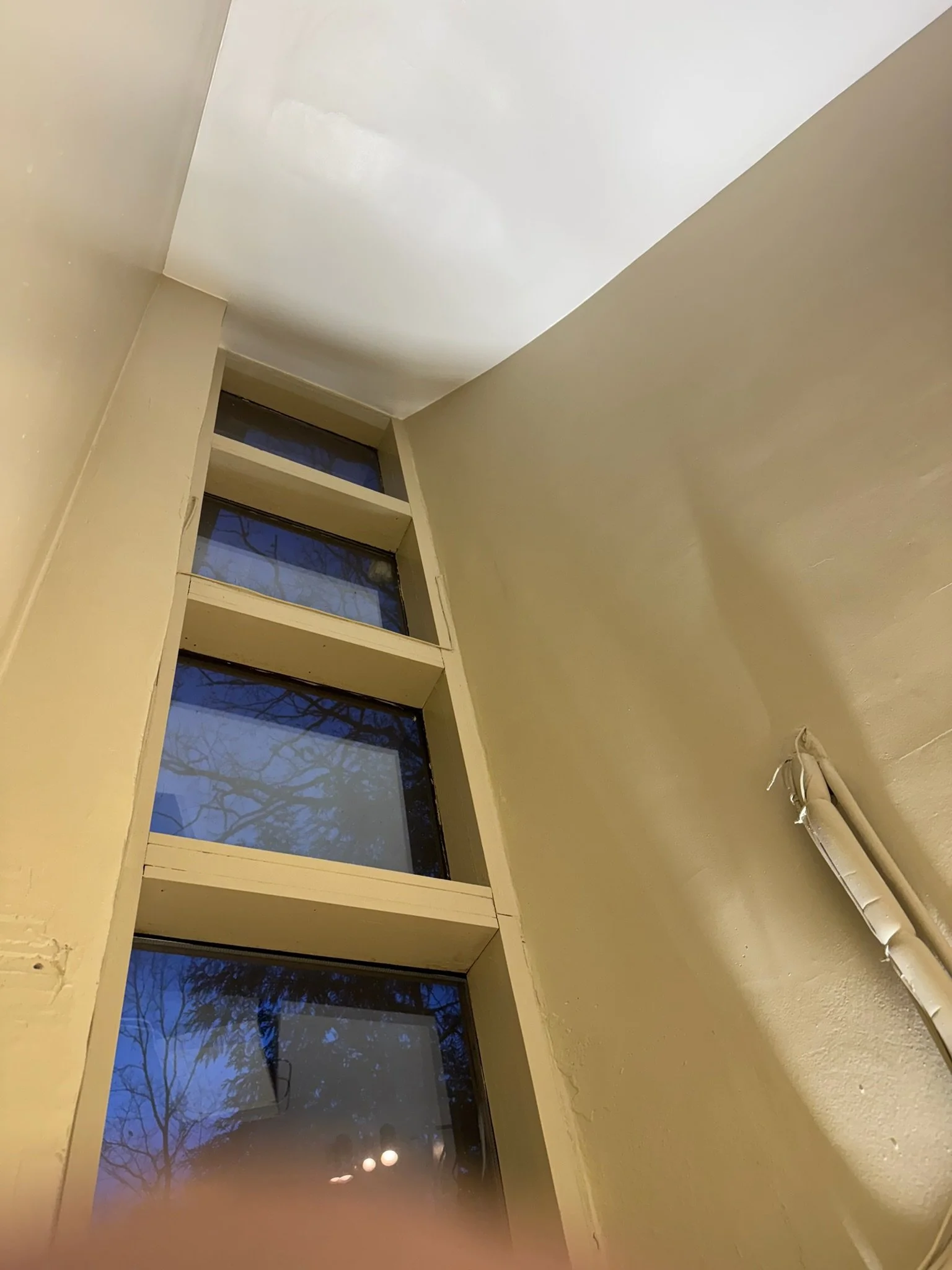 After repair: smooth, painted ceiling above the window.