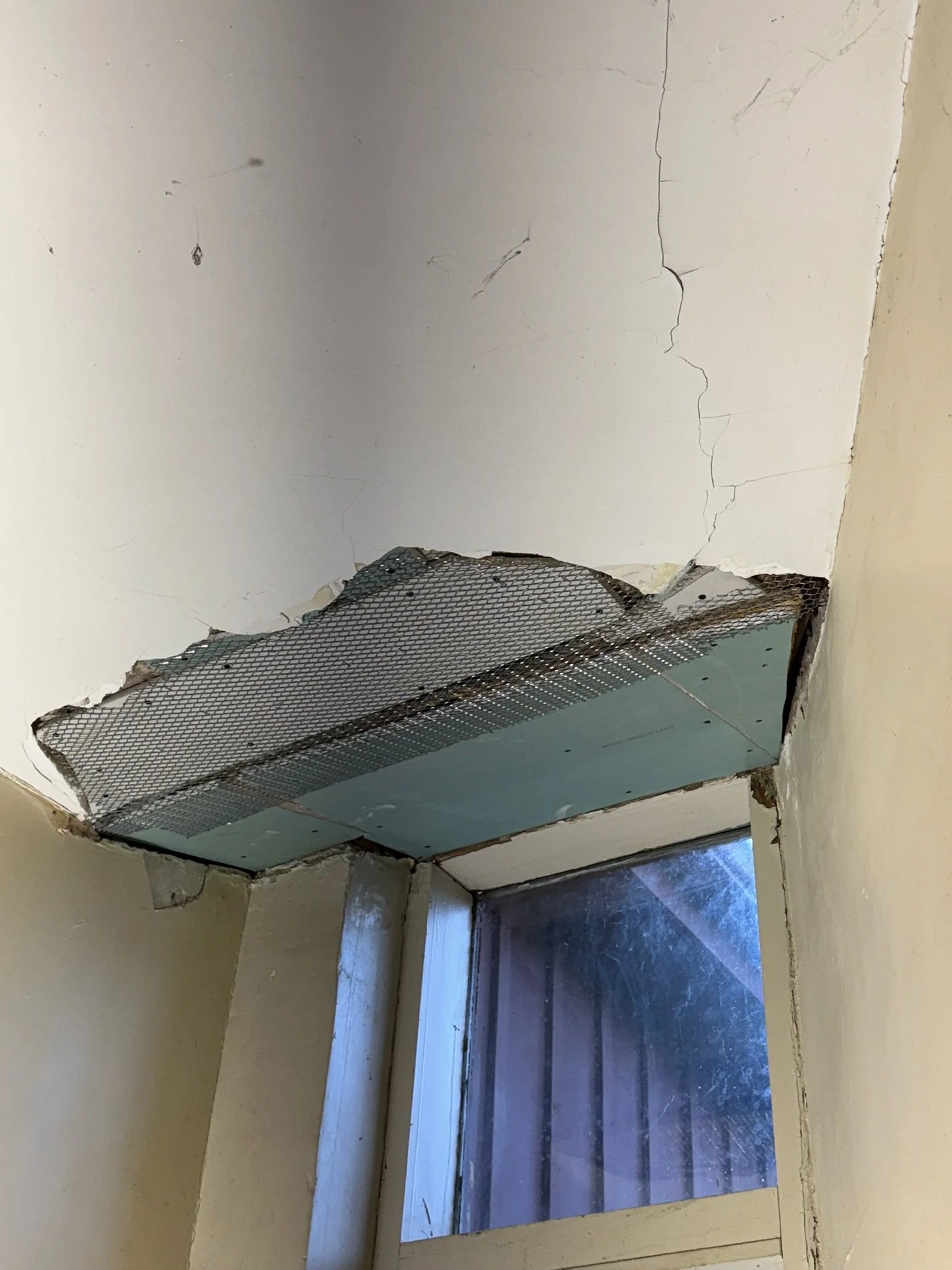 Ceiling repair in progress: metal lath across the patched area.