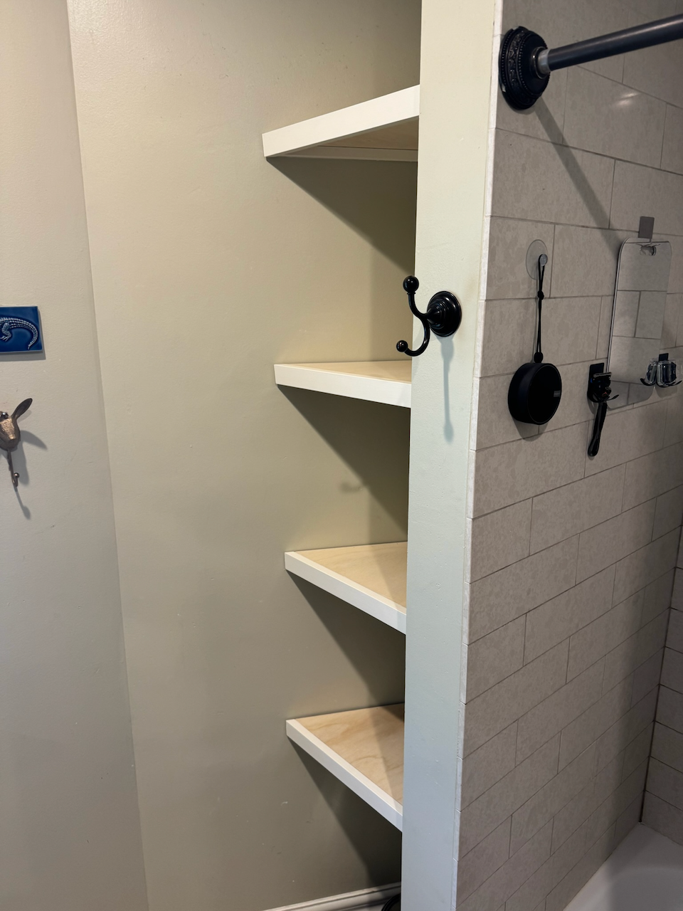 Custom white corner shelves beside the closet hanging area.