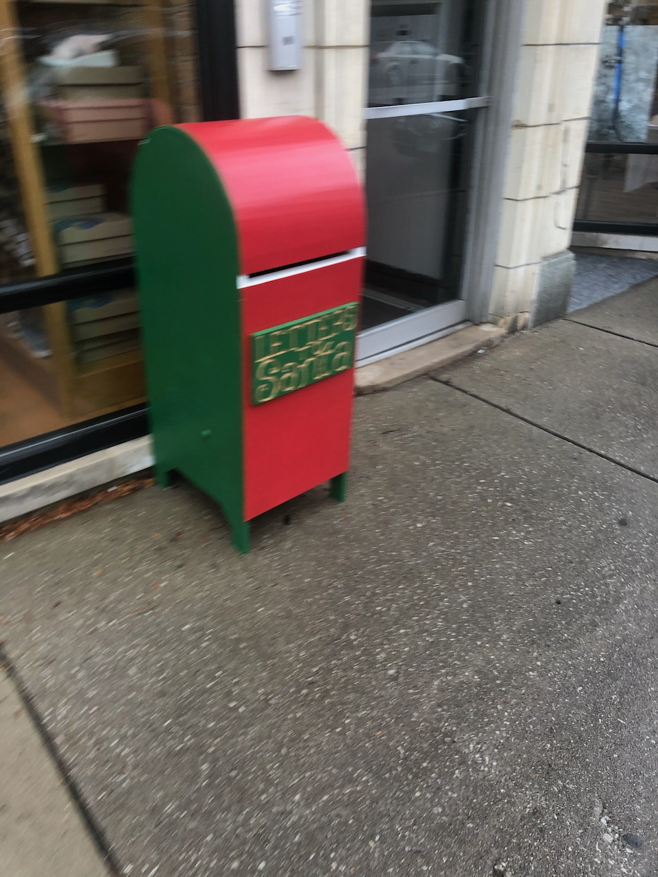 Side view of the curved red top and green mailbox body.