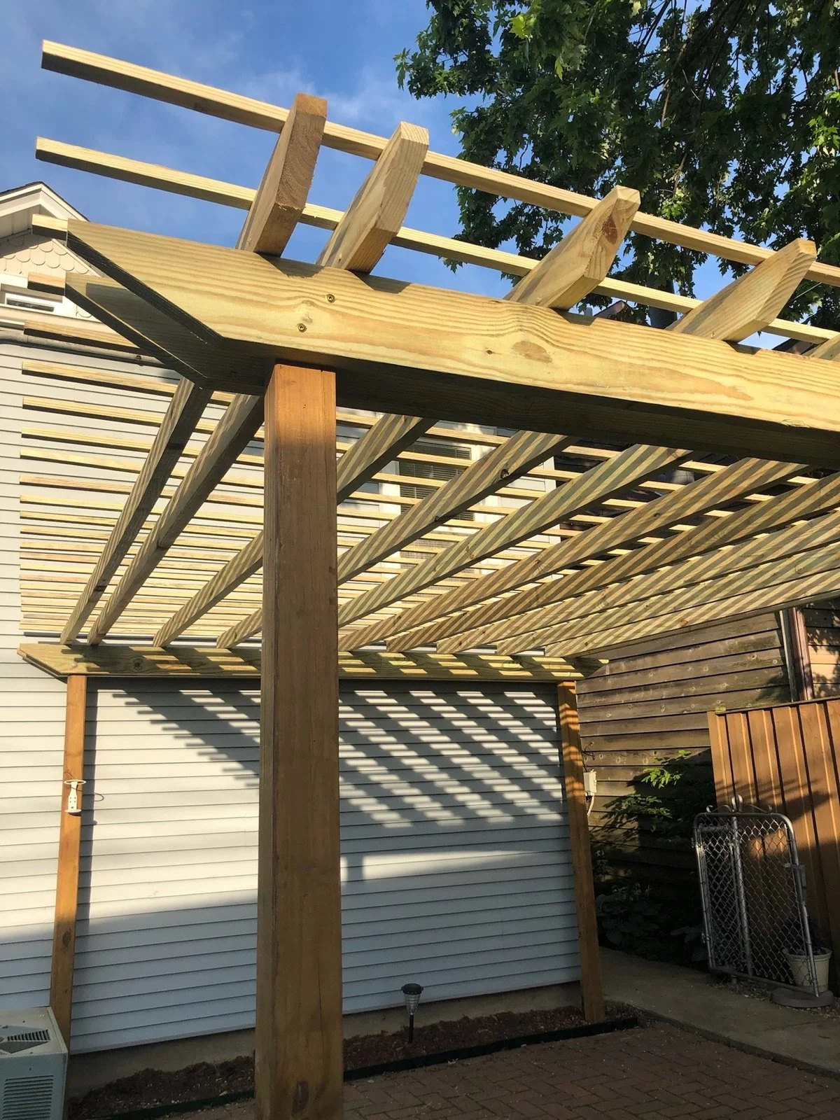 01-completed-wood-pergola-with-open-rafters-beside-the-house.jpg