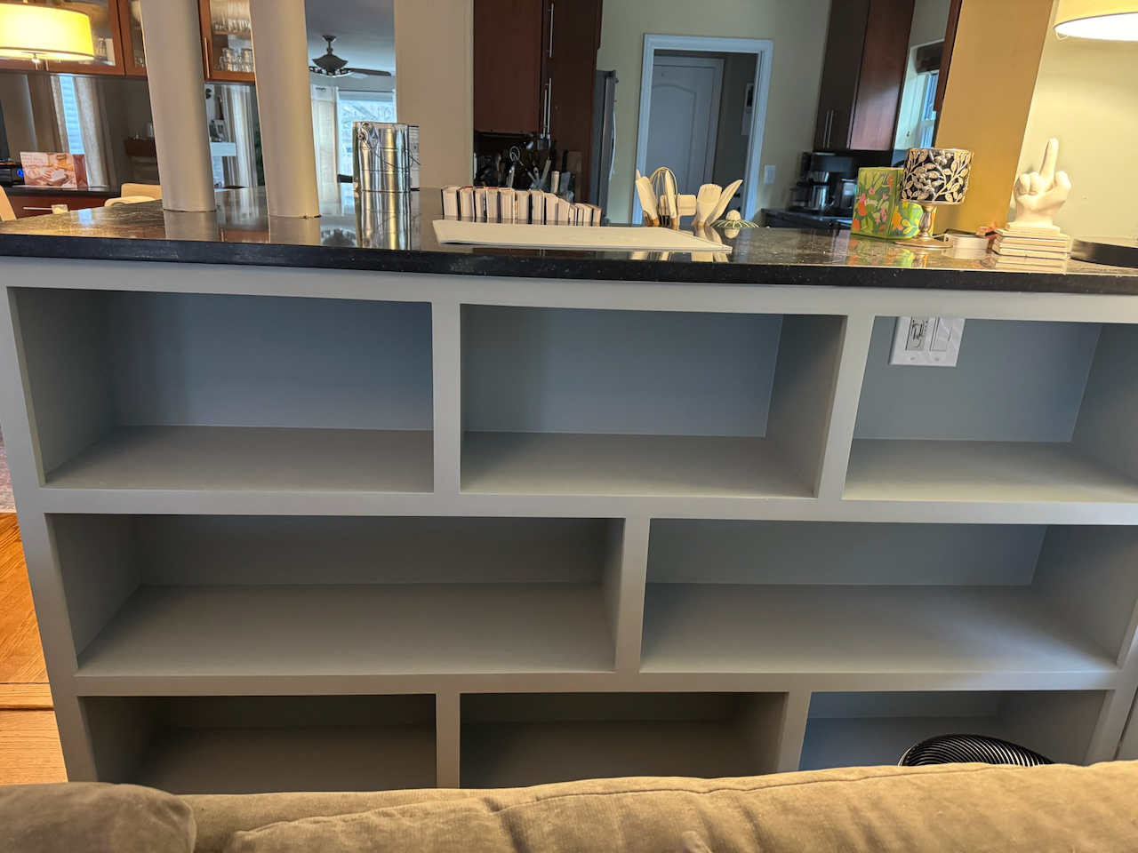 Finished sofa-back bookcase with open display shelves and a contrasting dark top.