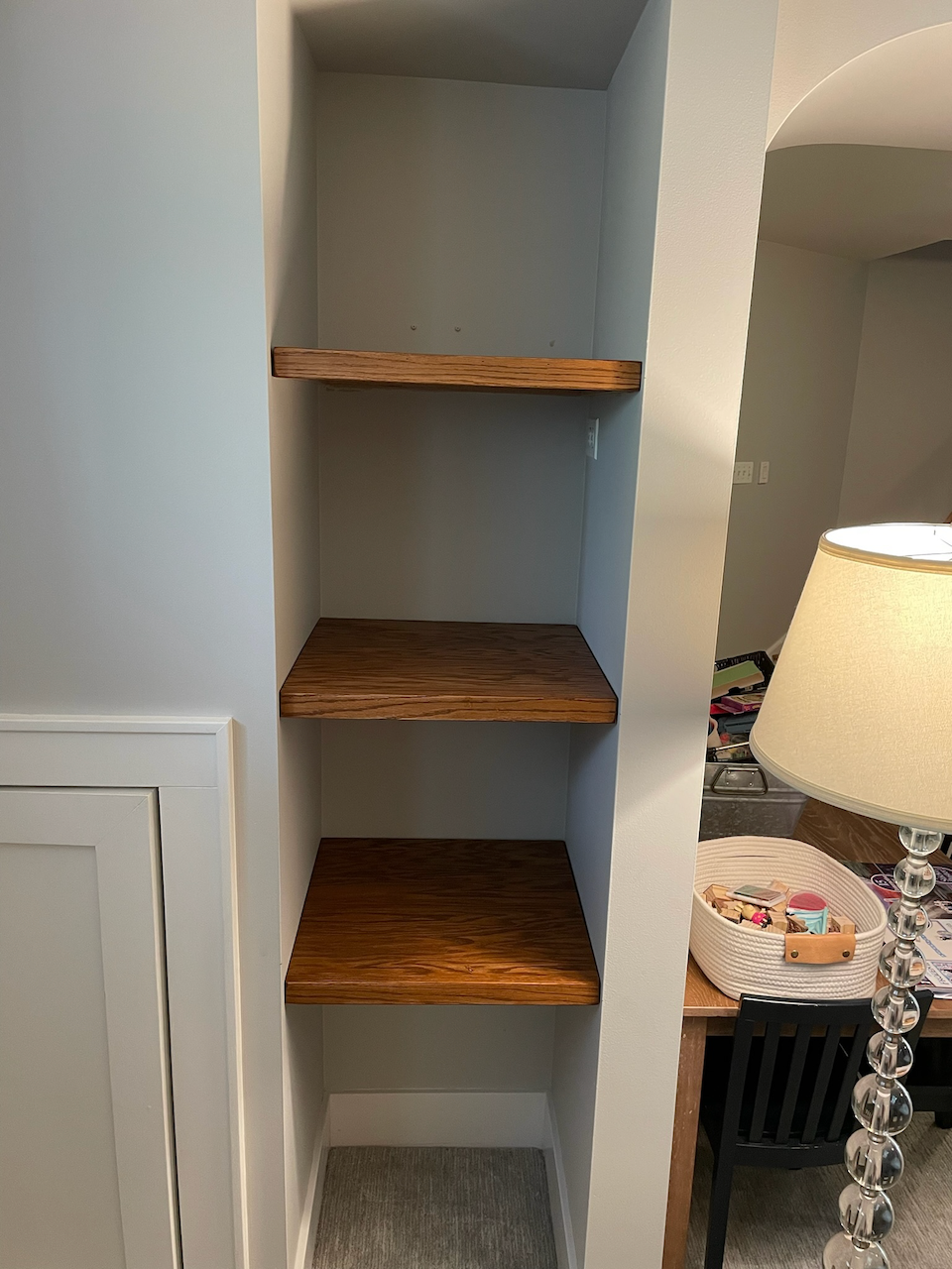 Close view of the thick wood shelves and painted niche walls.