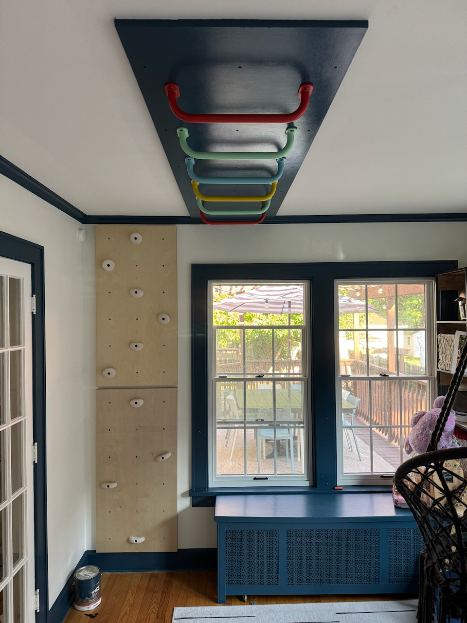 Finished rainbow monkey bars mounted on a dark ceiling panel.
