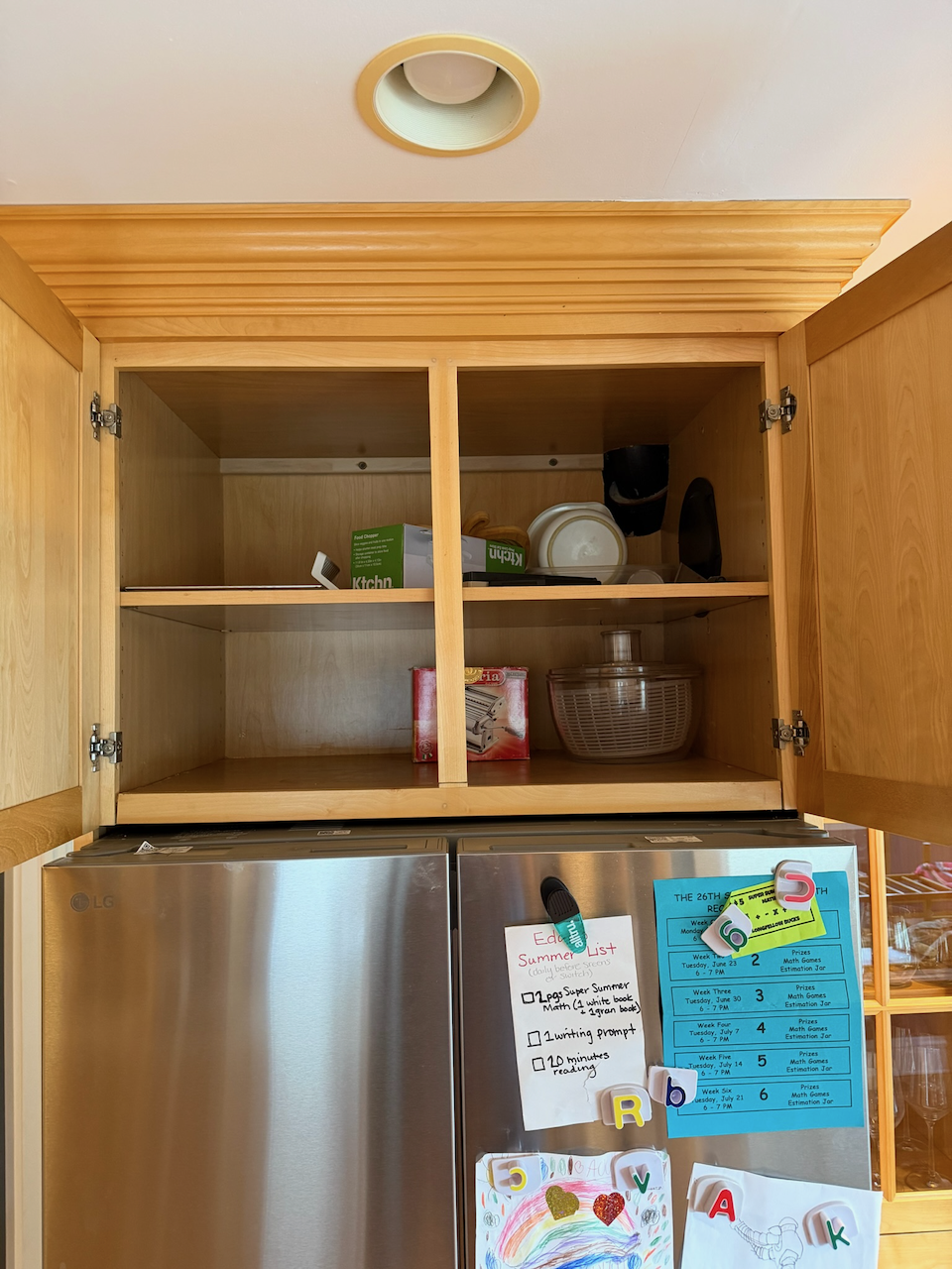 Open cabinet doors showing the storage shelves above the refrigerator.
