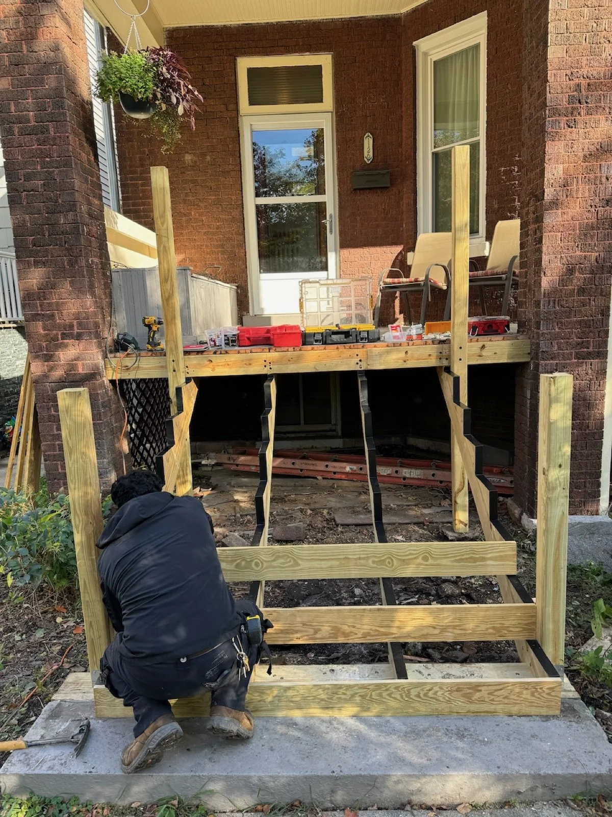 Porch stair structure during repair, with damaged treads removed.