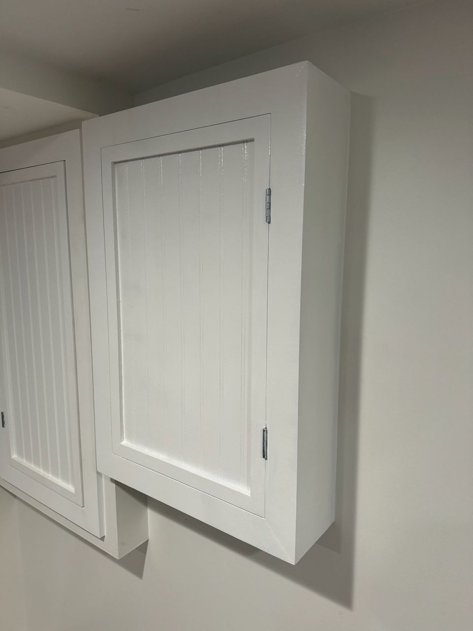 White paneled cabinet doors covering the utility access area.