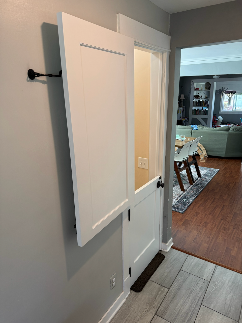 Custom white split Dutch door with inset panels and black hardware.