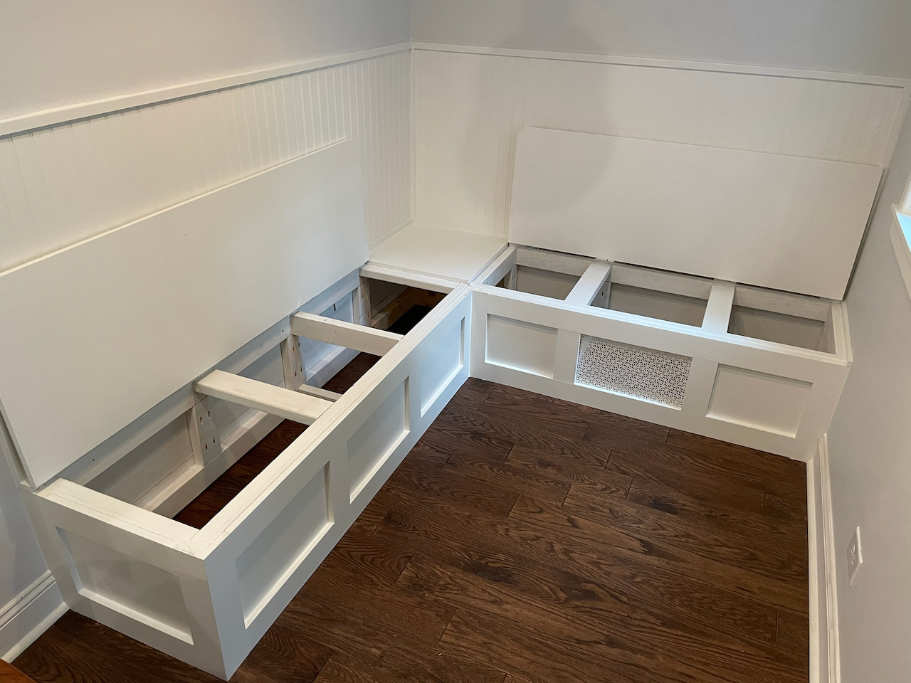 Kitchen banquette during construction, showing the open bench storage frames.