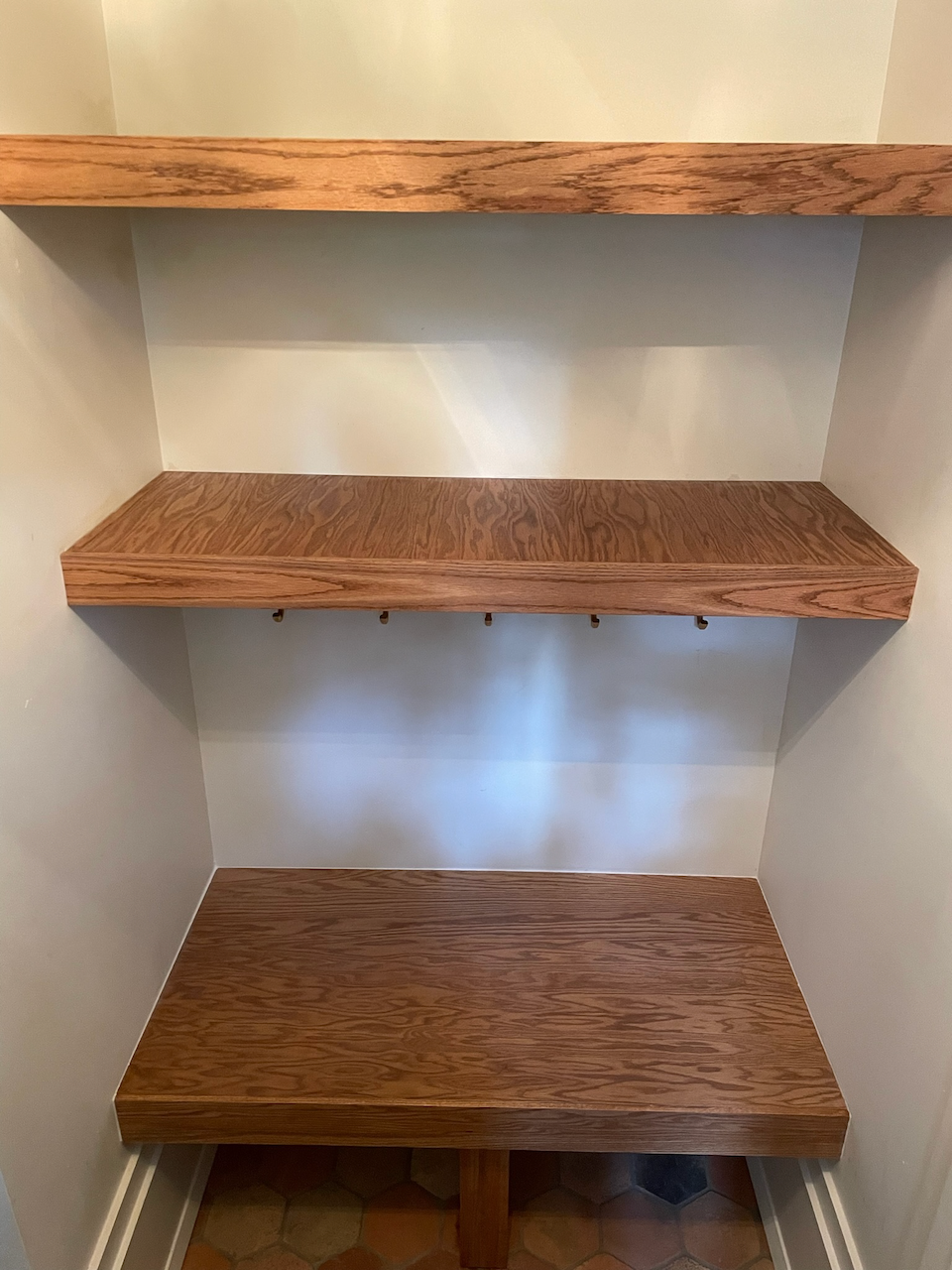 Custom oak bench and wood shelving fitted into the entry nook.