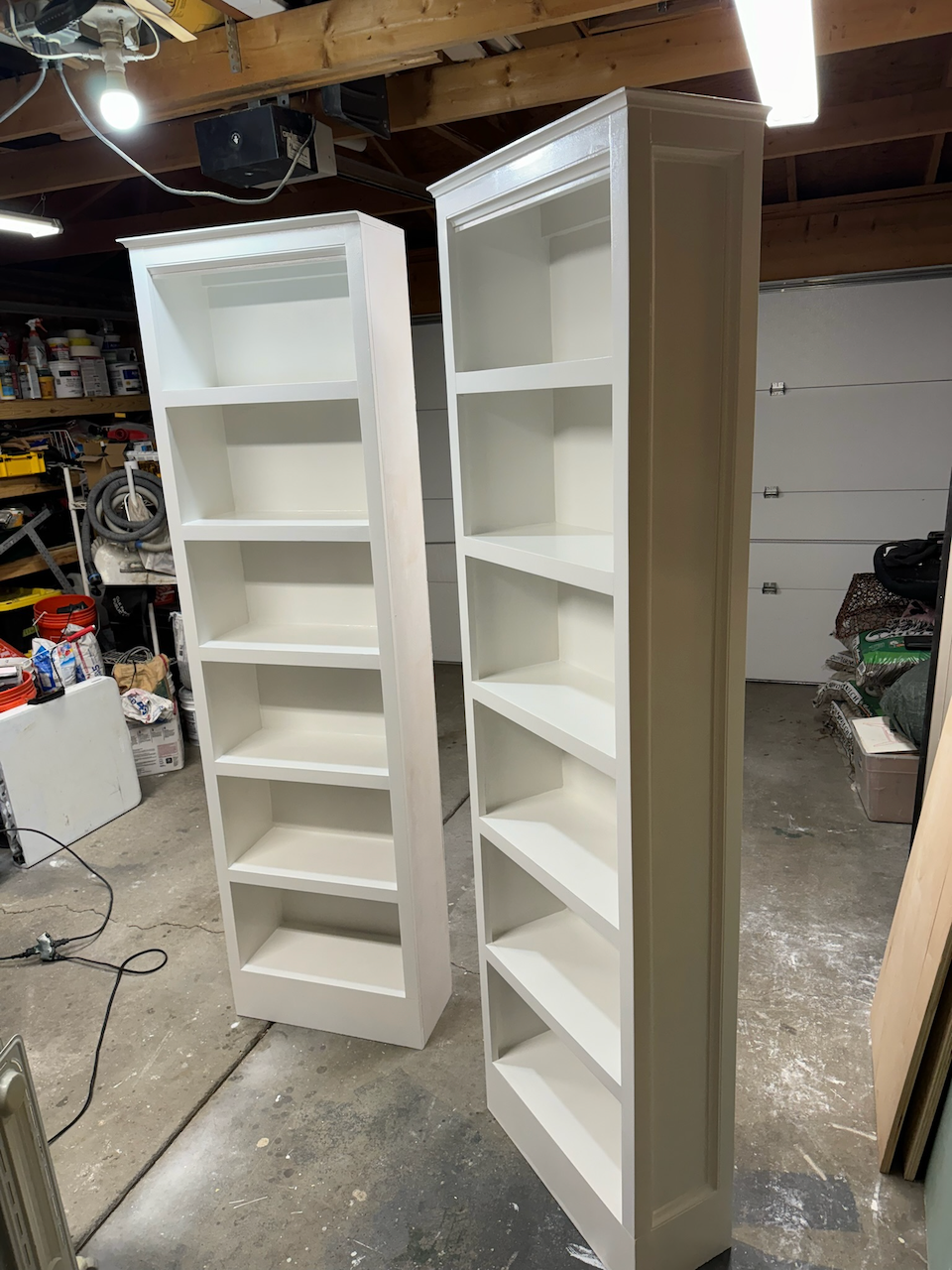 During: two custom white bookcases in the workshop before installation.