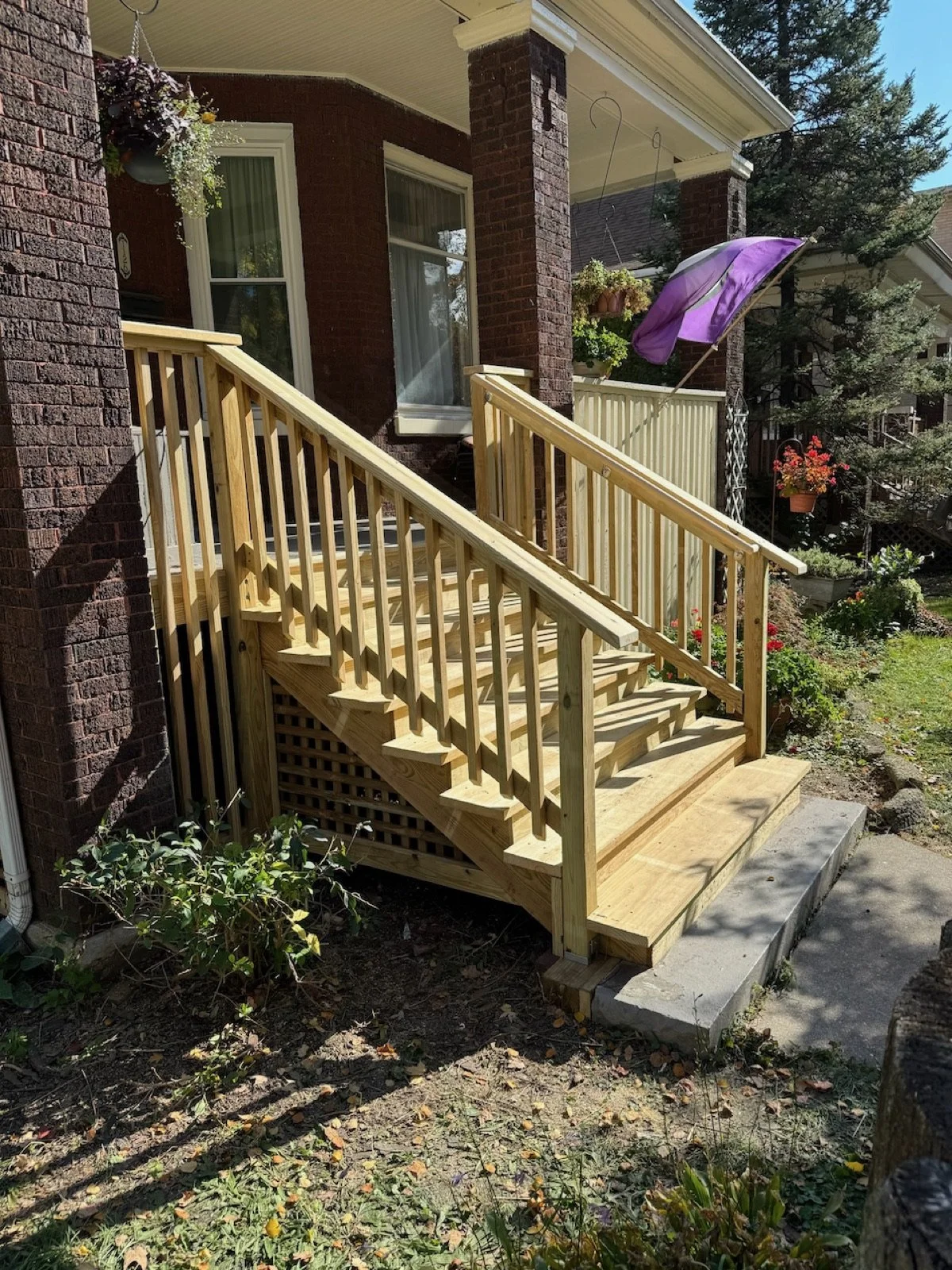 Side view of replacement porch stairs with wood balusters and handrails.