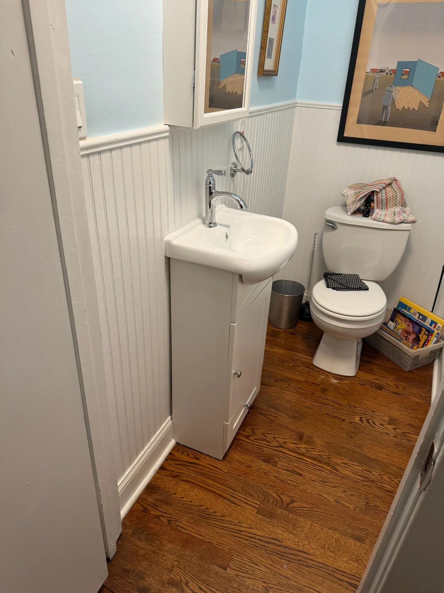 Compact vanity and faucet in a narrow powder room.