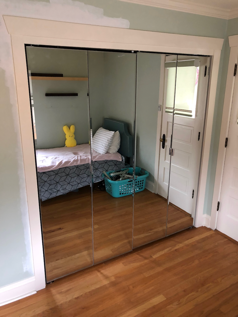 After: widened closet opening with fitted mirrored doors and white casing.