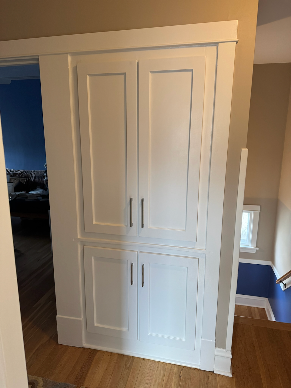 Completed white paneled linen cabinet.