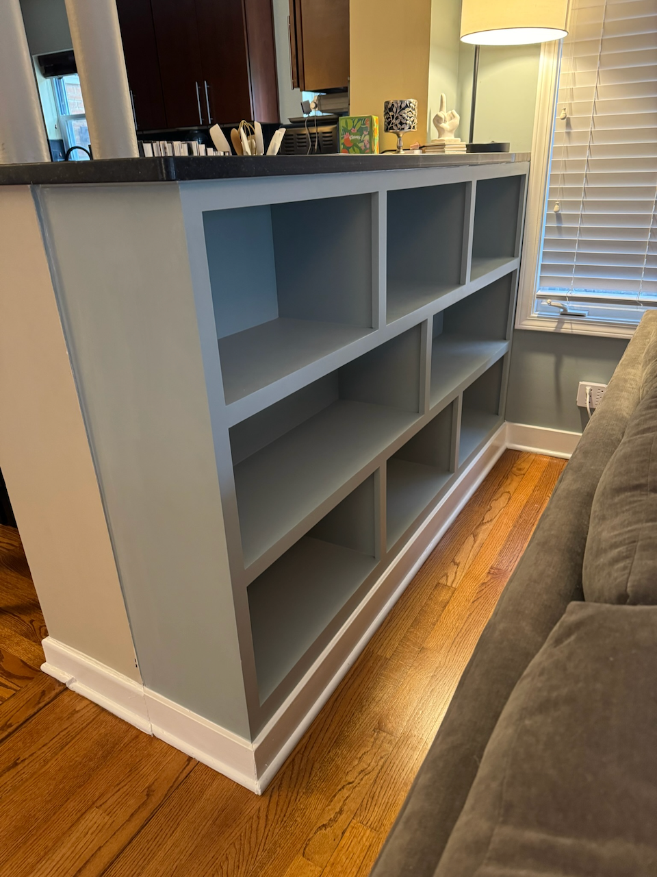 Angled view of the installed white bookcase behind the sofa.