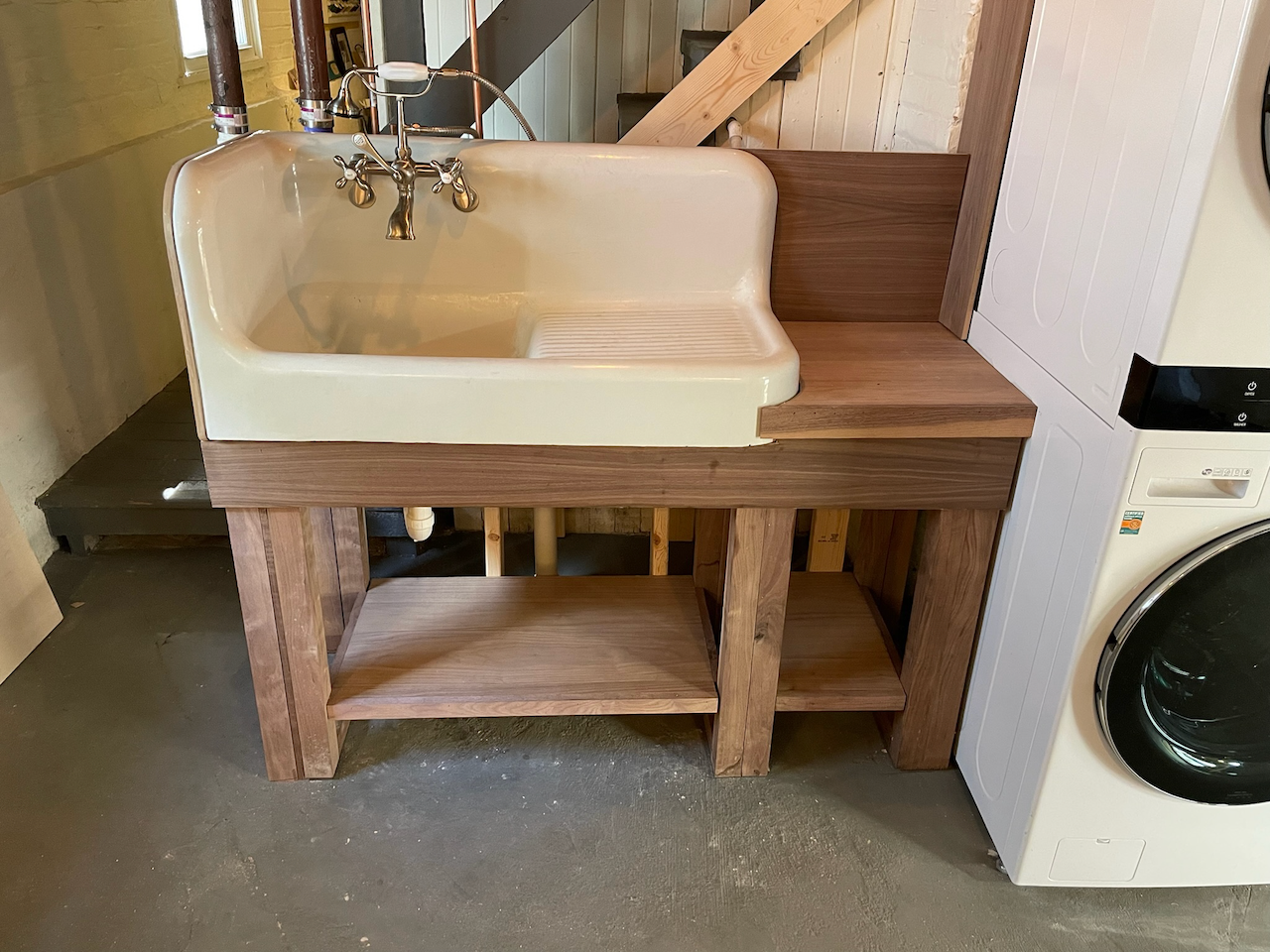 Front view of the fitted wood sink stand beside the washing machine.