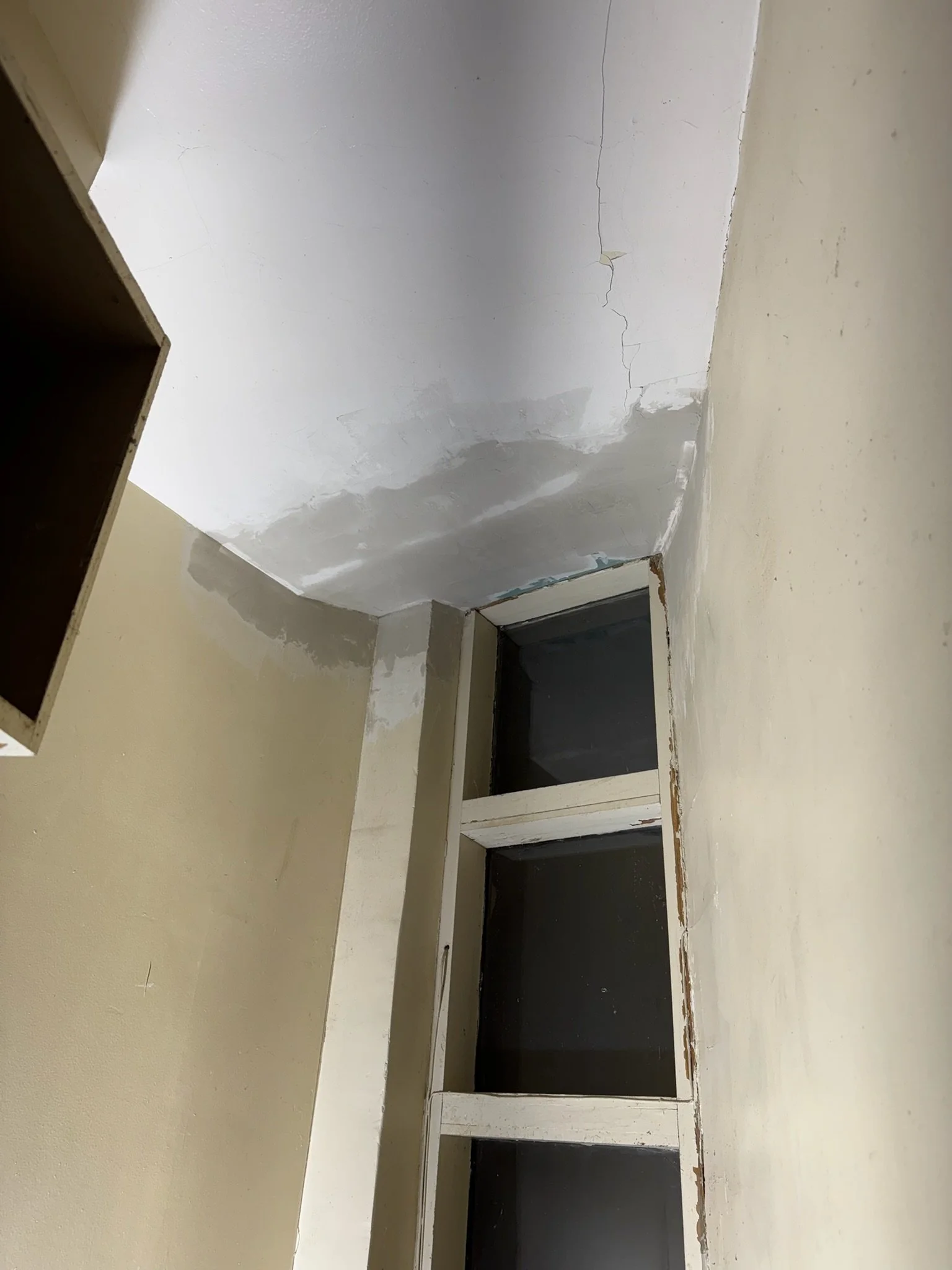 Ceiling repair in progress: plaster coating over the patched area.