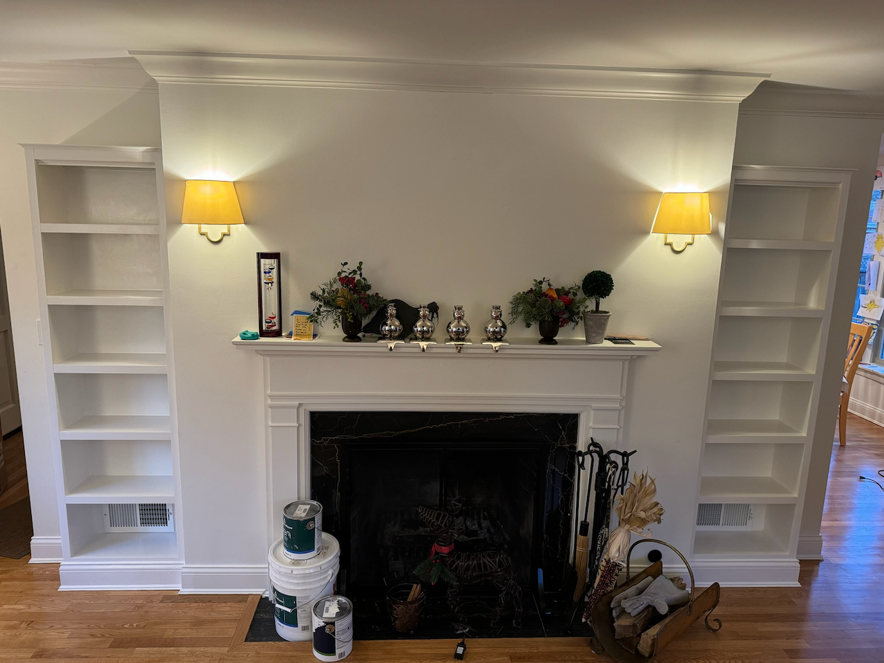 Pair of white built-in bookcases framing the fireplace.