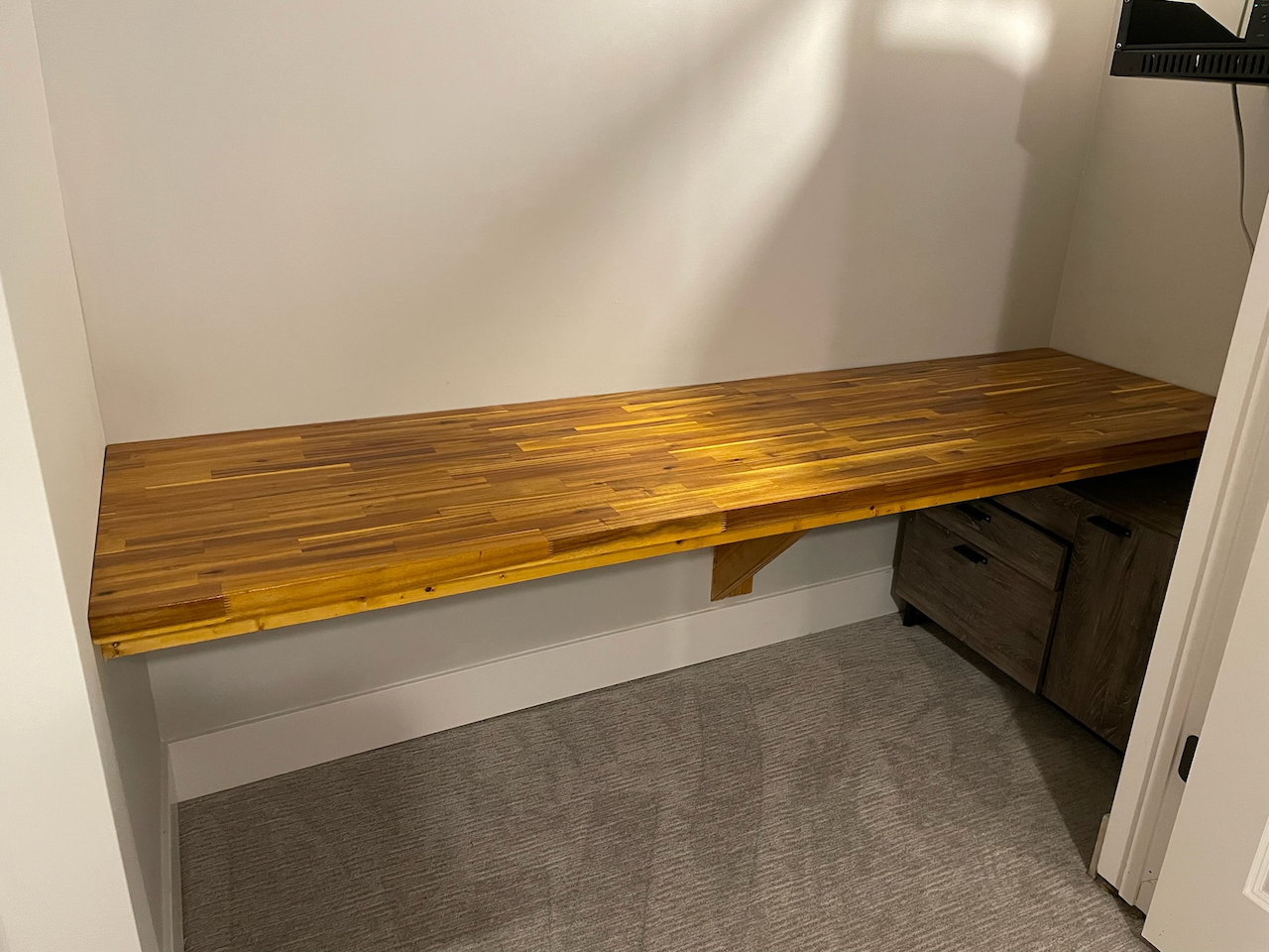 Custom natural wood bench fitted wall to wall inside the closet.