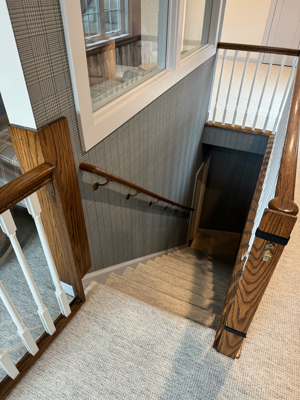 Stairwell railing and wall handrail in the same landing area.