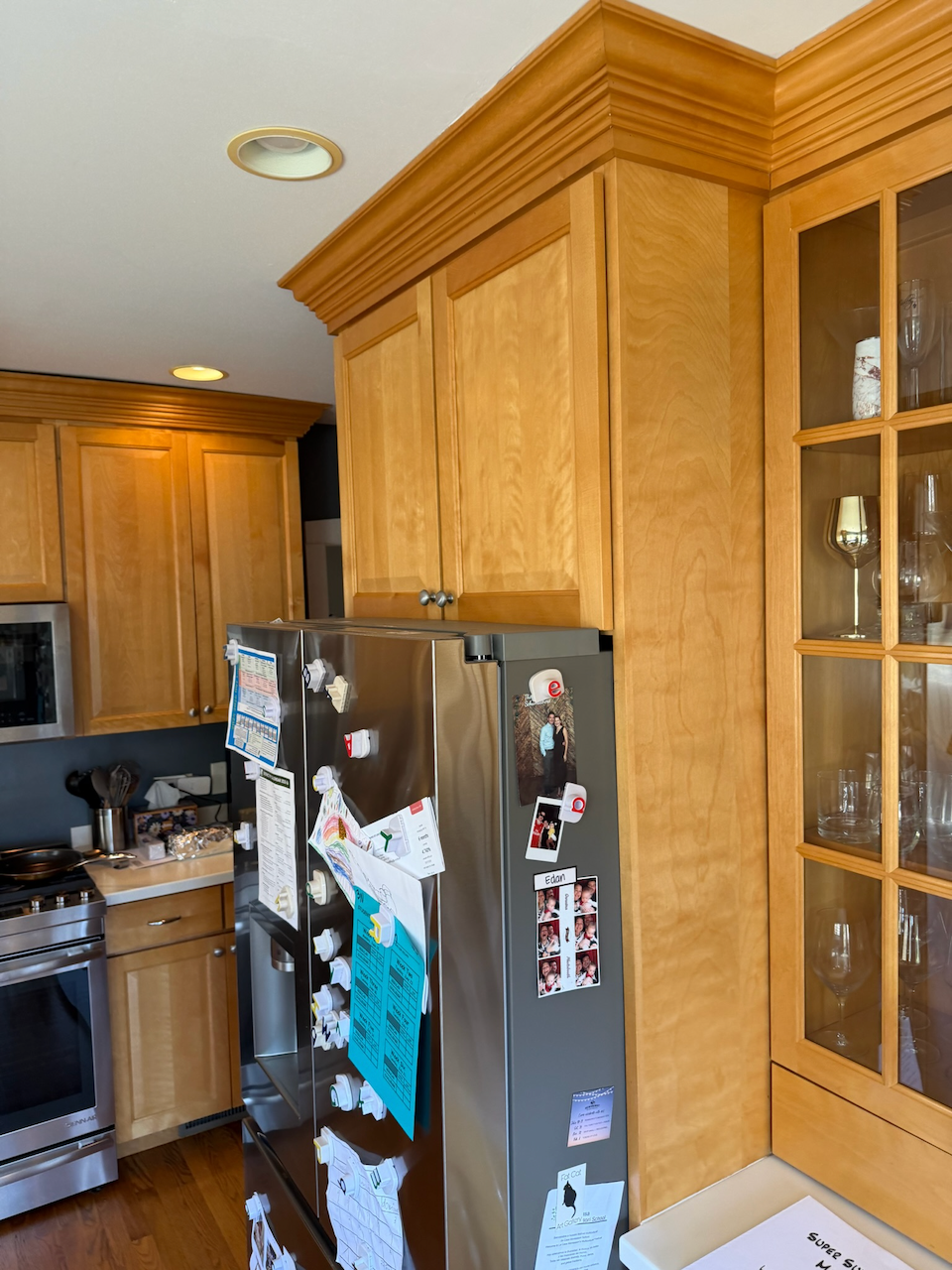 Wood cabinet surround and crown molding fitted above the refrigerator.